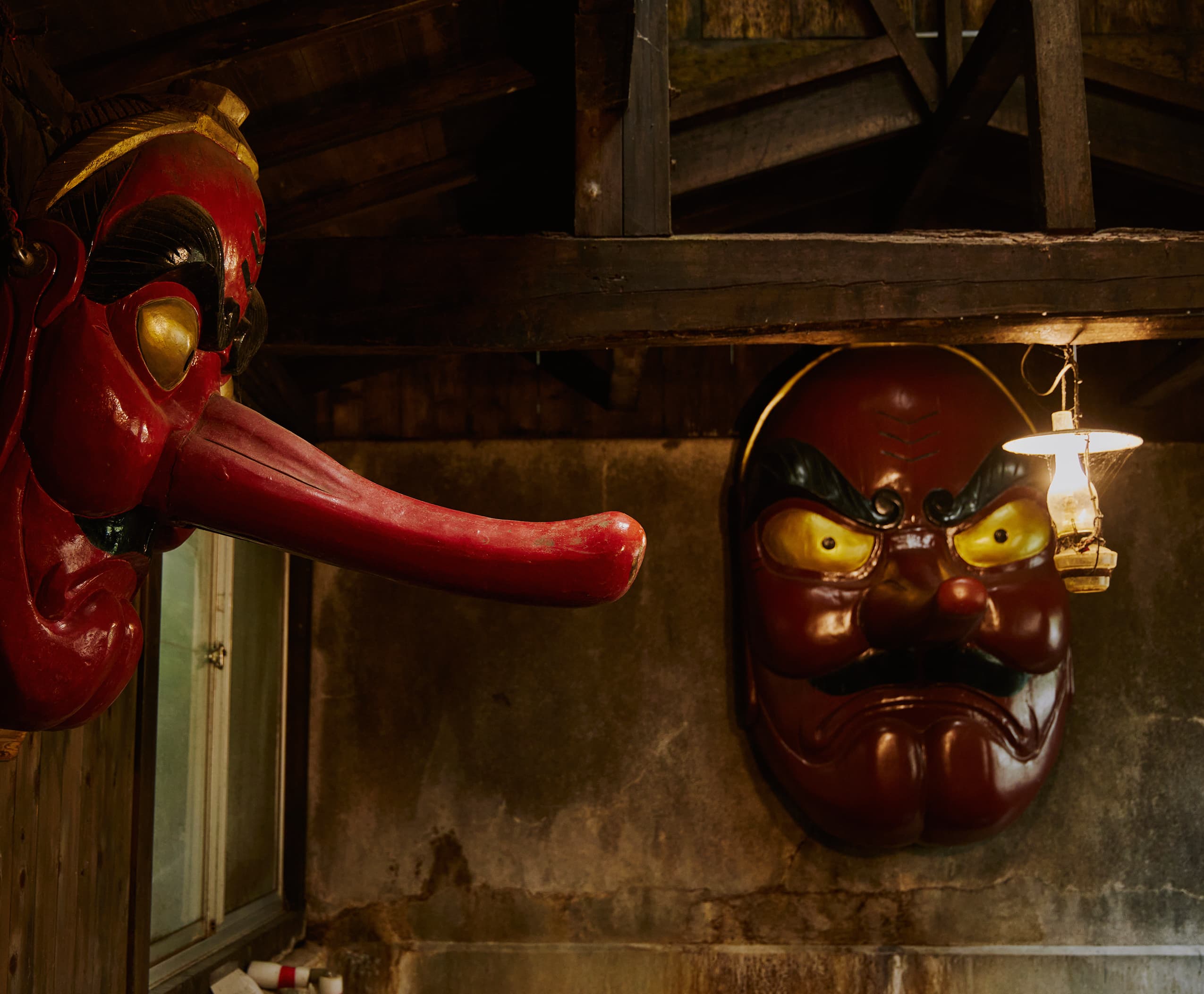 Large red long-nosed Tengu mask displayed in the bathhouse
