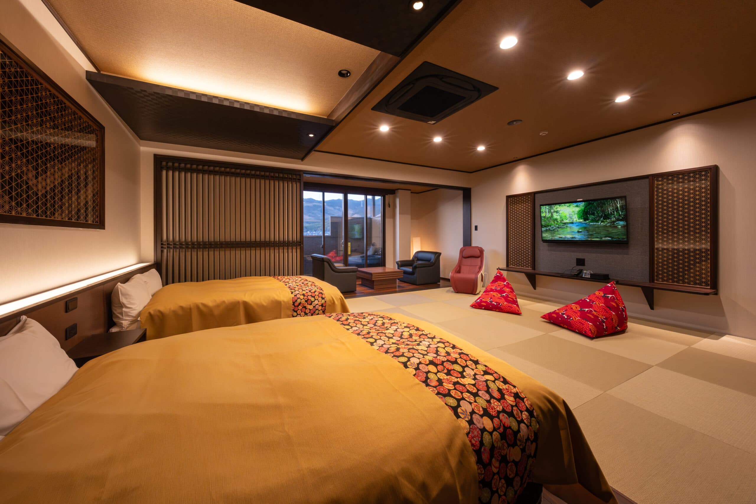 Premium Yuzen twin-bed room at Kiyonoya with warm lighting, tatami floor and a wall-mounted television