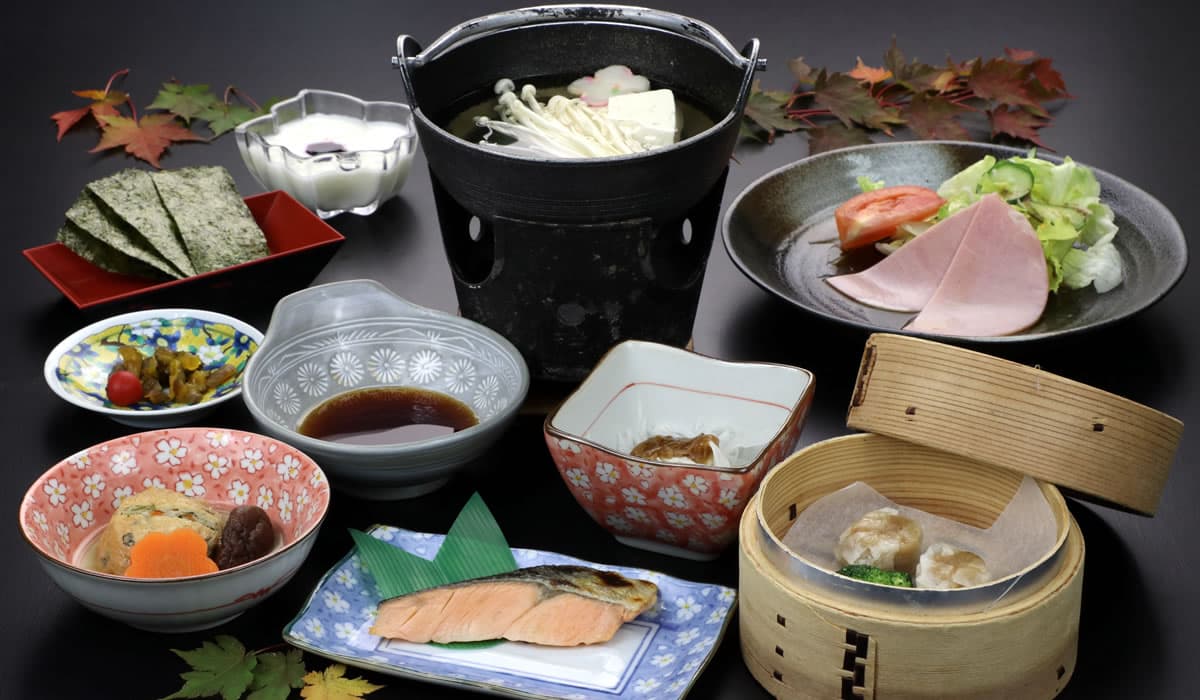 Japanese breakfast set with grilled salmon, hot pot, steamed dumplings, pickles and small side dishes