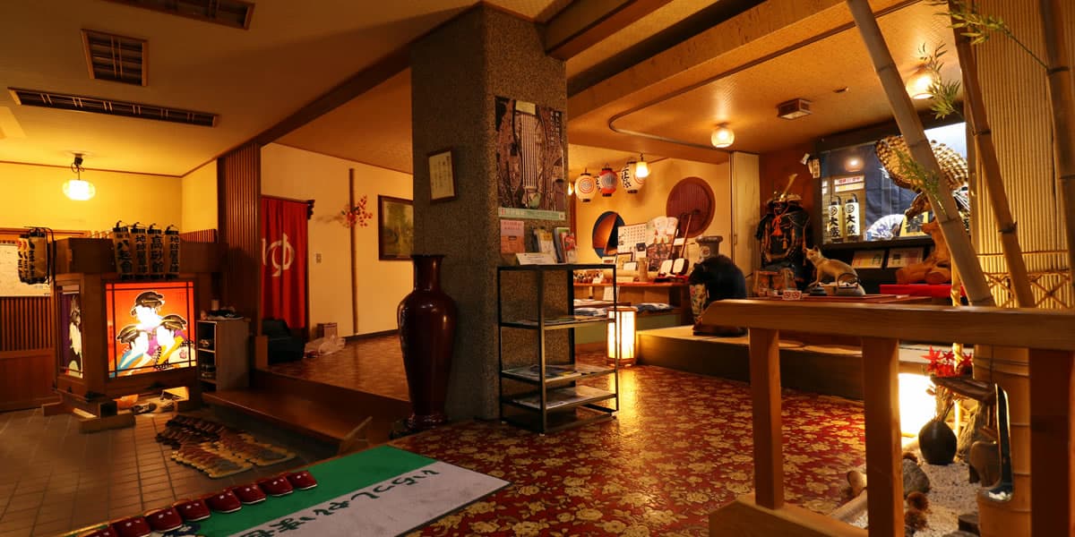 Warmly lit traditional inn lobby with paper lanterns, antique decor and a folk-art display