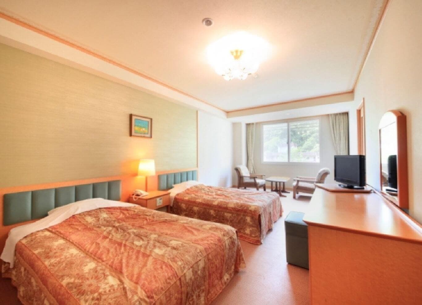 Western-style twin guest room with patterned bedding and a window onto the hillside at Park Hotel Miyabitei in Noboribetsu Onsen
