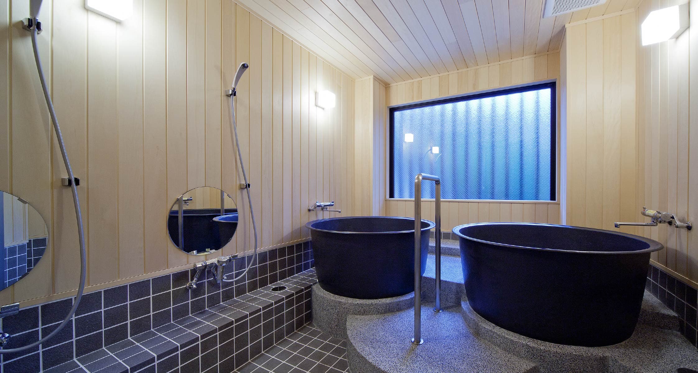 Private bath at Mizuhaso with two deep ceramic soaking tubs and hinoki wood-panelled walls