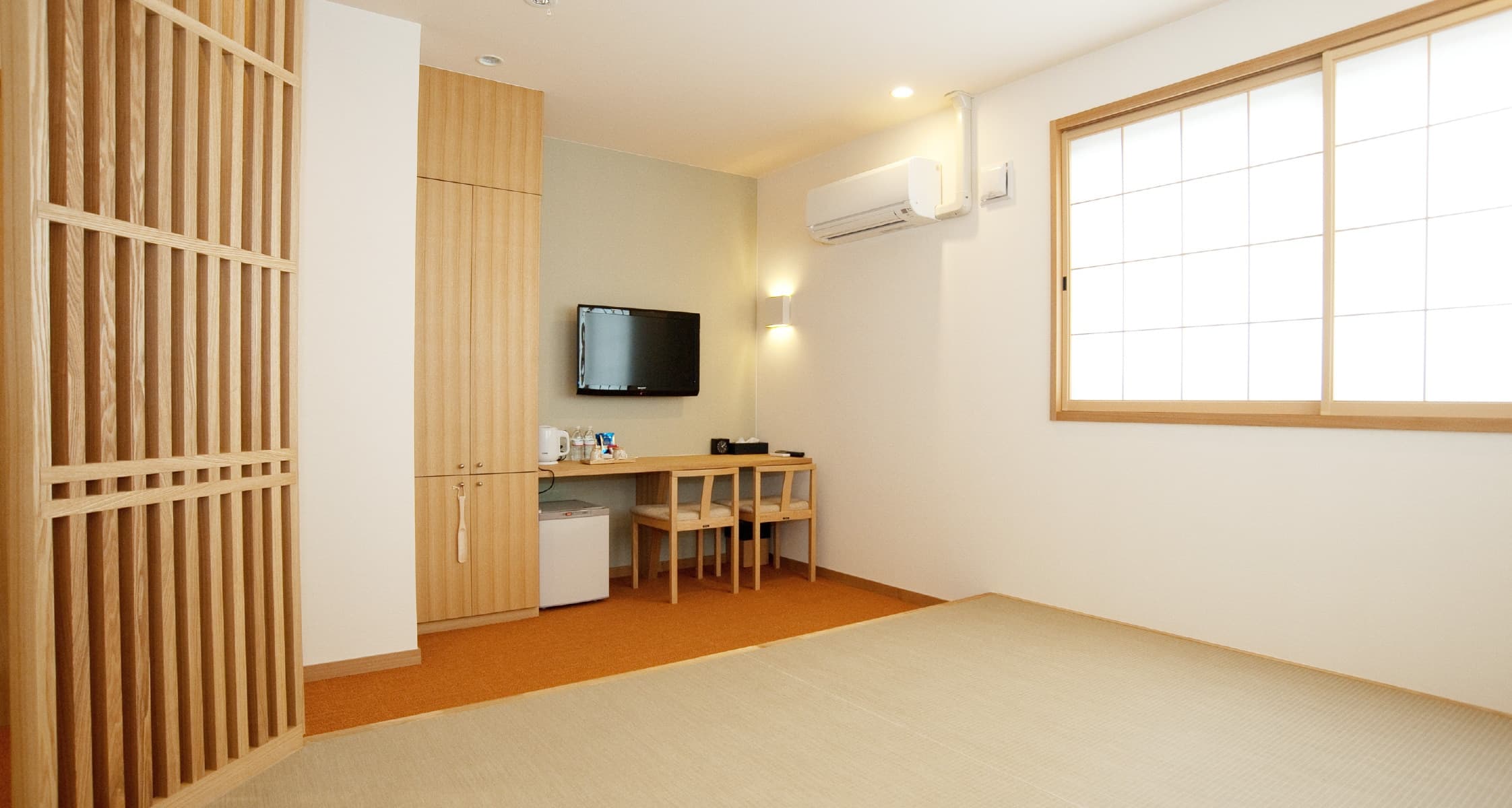 Bright tatami guest room at Mizuhaso with grid-lattice window and natural wood cabinetry