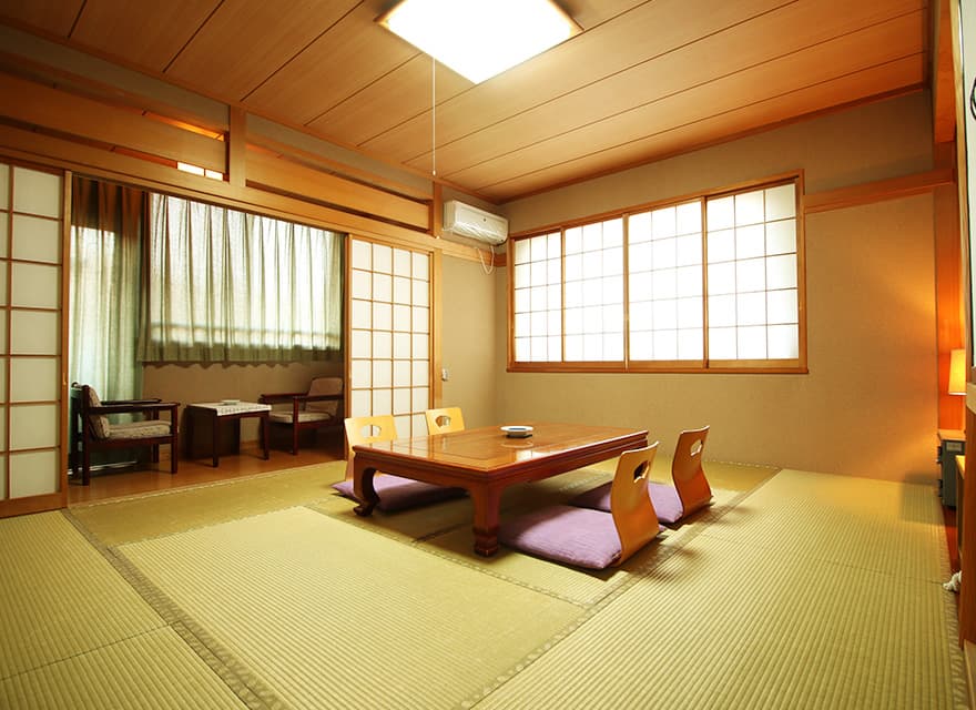 Bright tatami guest room with low table and paper-screened windows