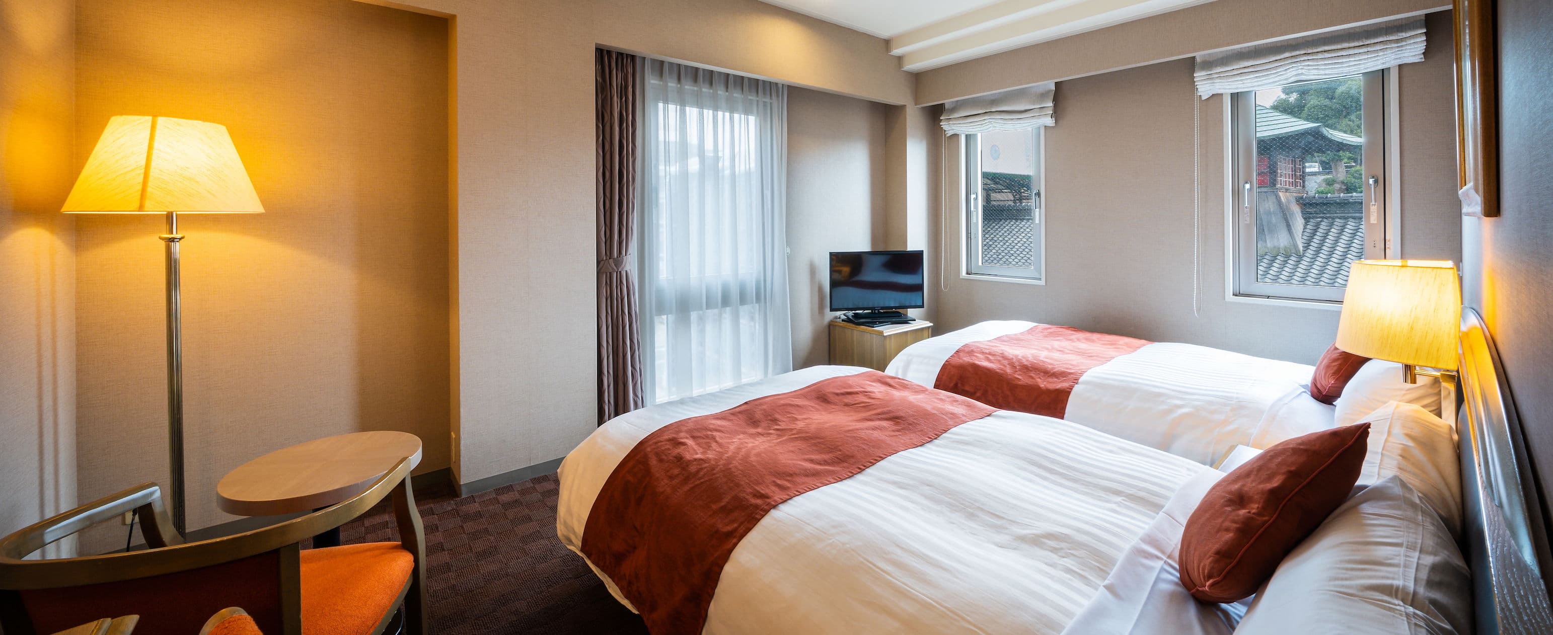 Twin guest room at Hotel Patio Dogo overlooking the Dogo Onsen Honkan rooflines