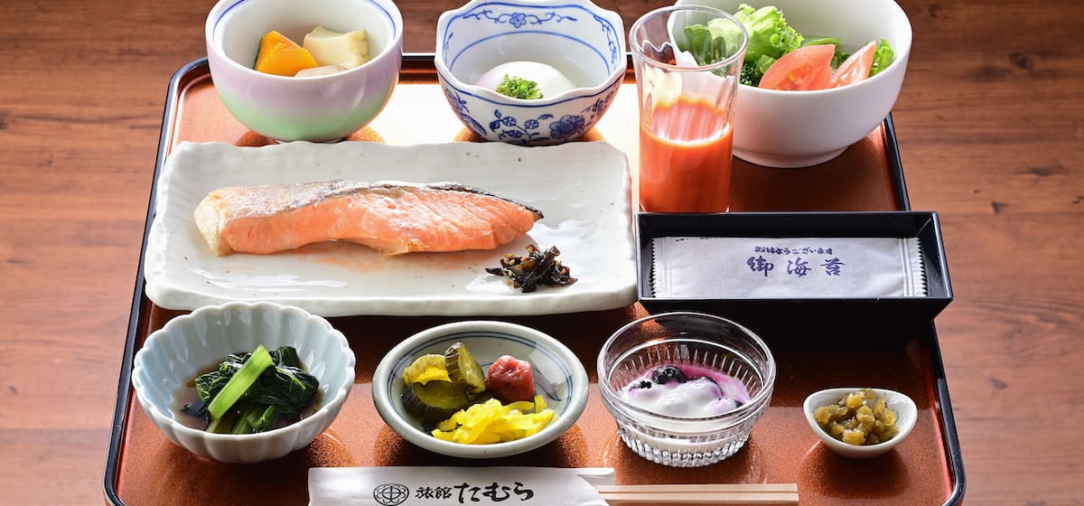 Japanese breakfast tray at Ryokan Tamura with grilled salmon, simmered vegetables, salad and pickles