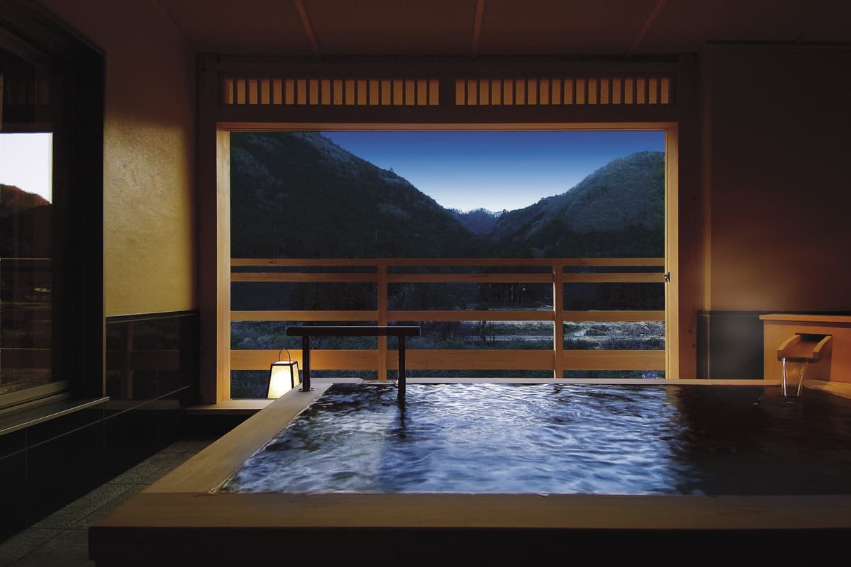 Semi-open-air stone bath framing a mountain view