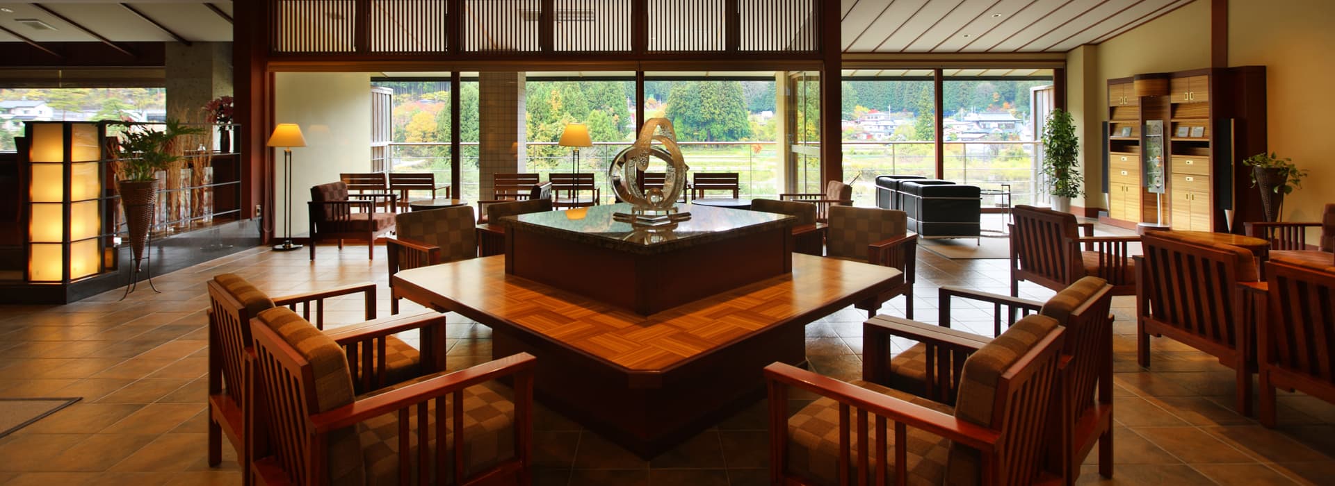 Lounge with wooden furniture and forest-facing windows