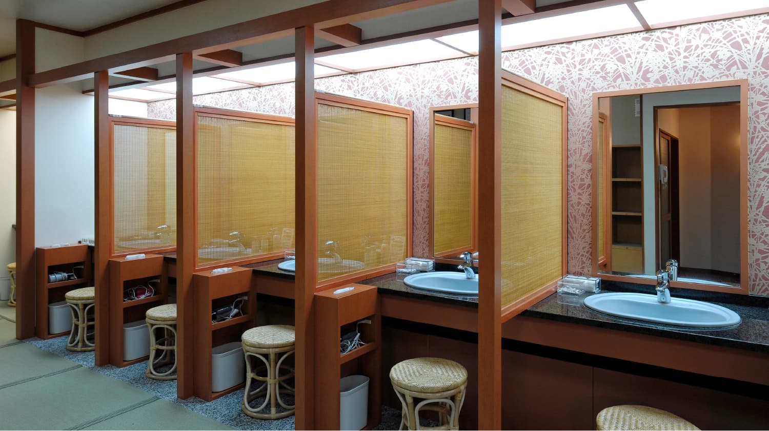 Tatami-floored powder room with bamboo-screened vanity stations and rattan stools at Shirafuneso Shintaku Ryokan, Shirahone Onsen