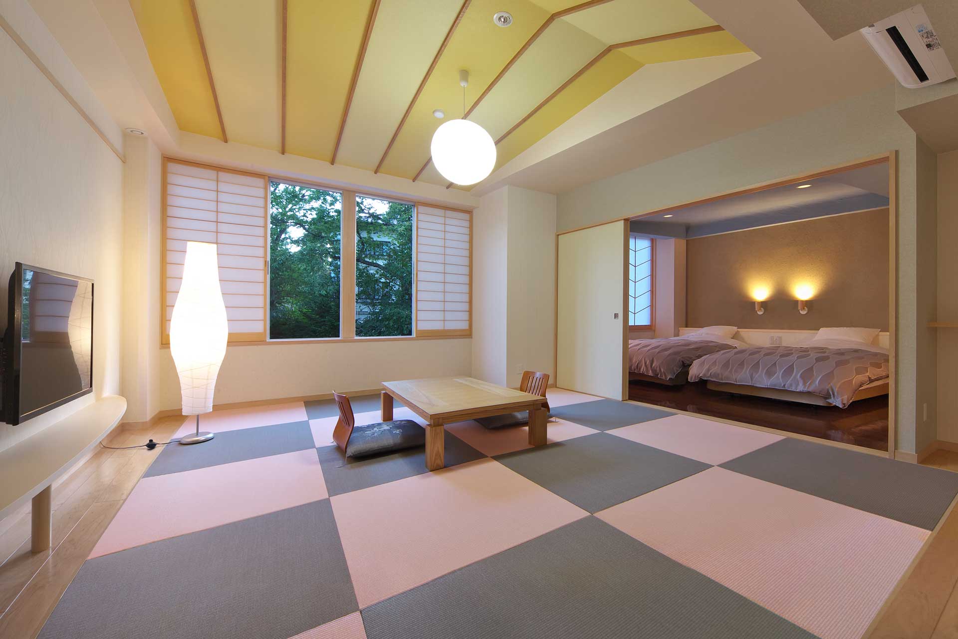 Modern Japanese-Western suite at Kusatsu Skyland Hotel Seifutei with checkered tatami flooring and a twin-bed sleeping area