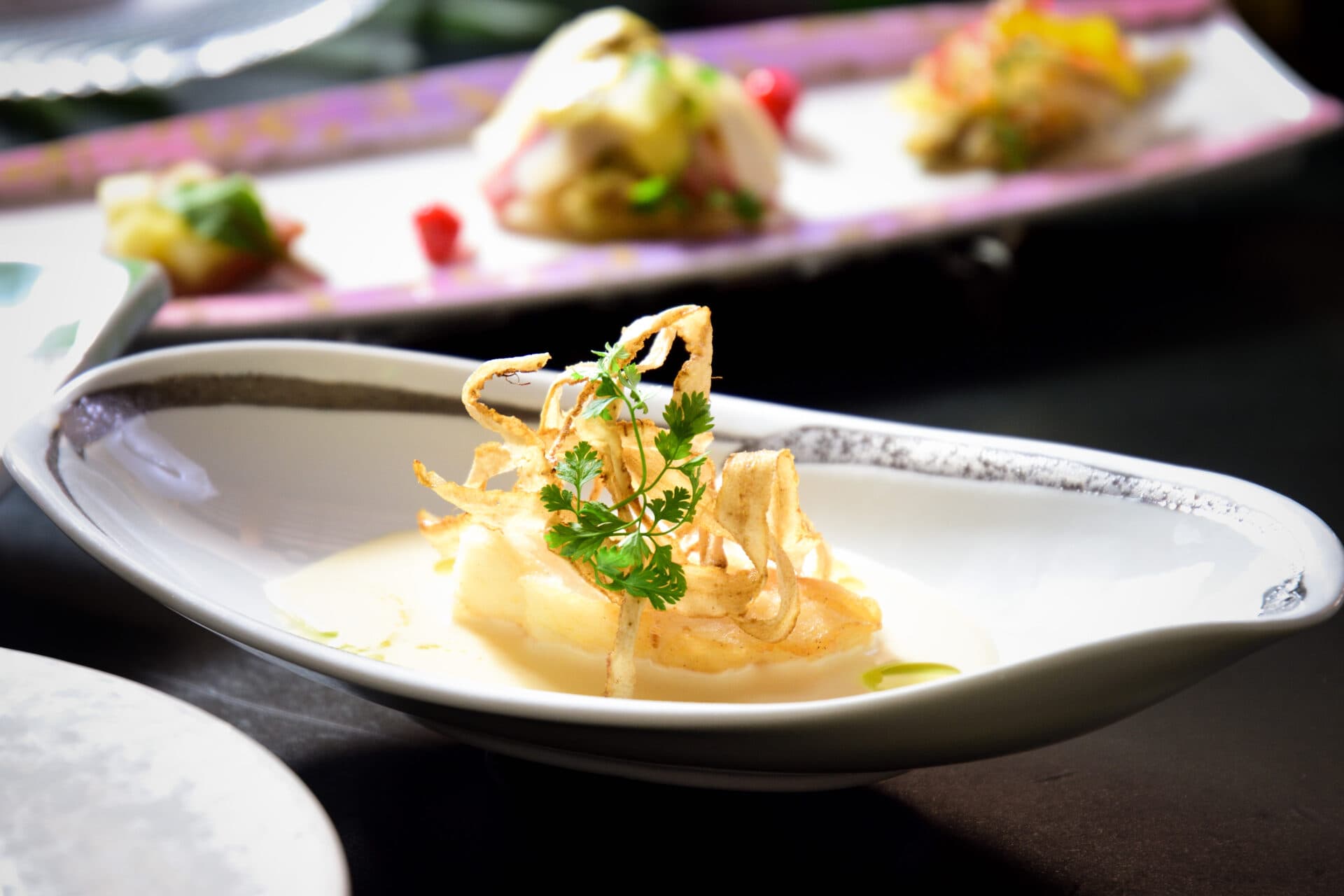 Kaiseki soup course at Kusatsu Skyland Hotel with white fish and crisp garnish in a leaf-shaped bowl