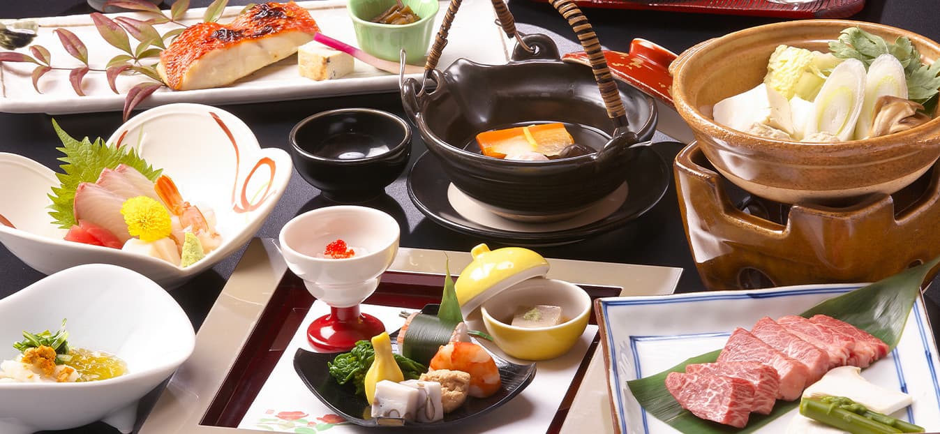 Multi-course Hida kaiseki dinner spread with sashimi, grilled fish, hotpot and Hida beef at Honjin Hiranoya Kofukan