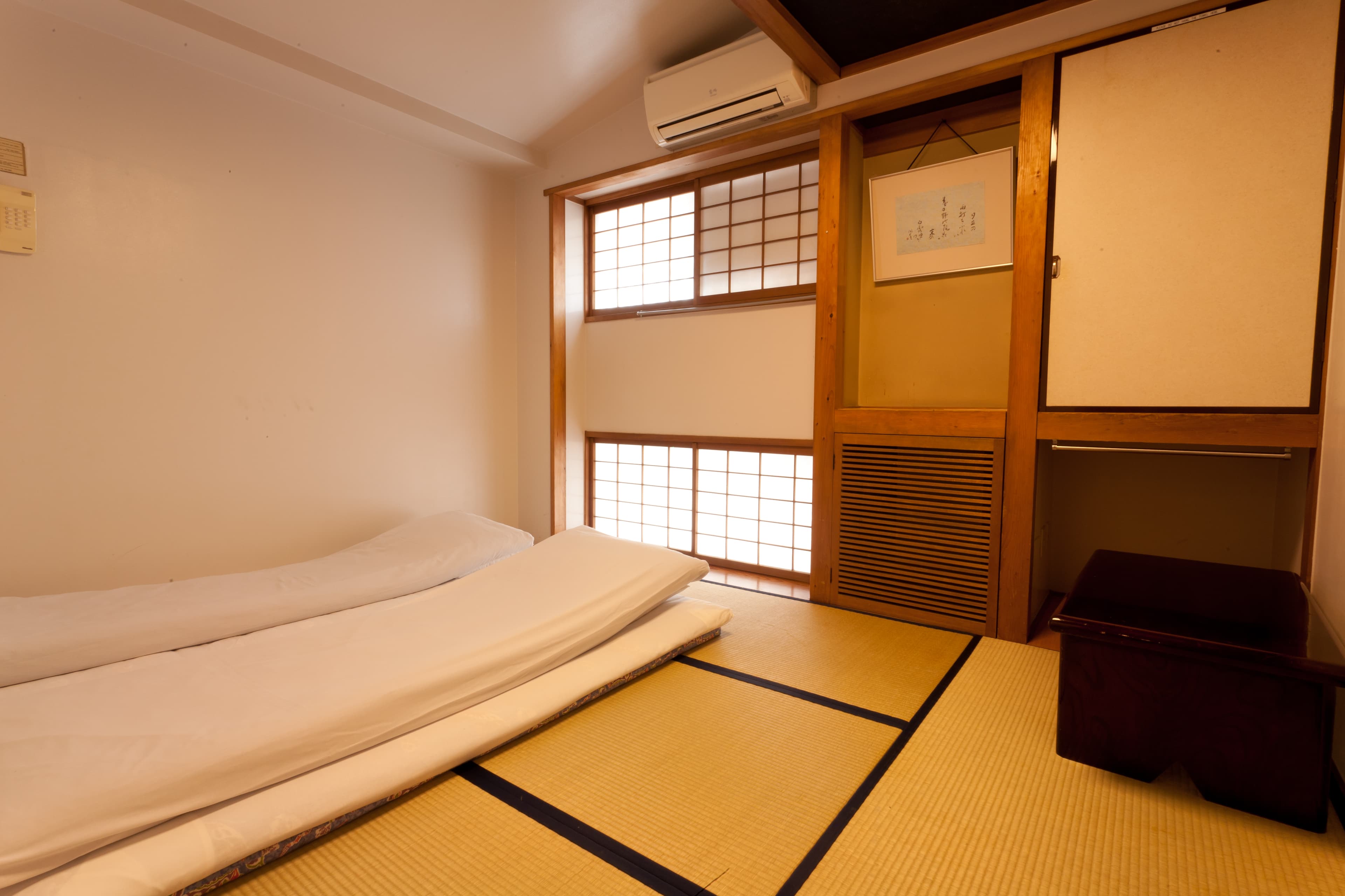 Single-futon tatami guest room at Kimi Ryokan with shoji screens, scroll alcove and tatami flooring