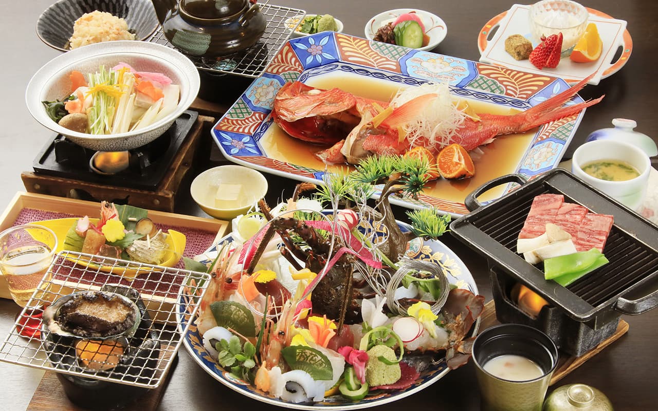 Multi-course kaiseki dinner spread with lobster sashimi, simmered kinmedai and grilled beef