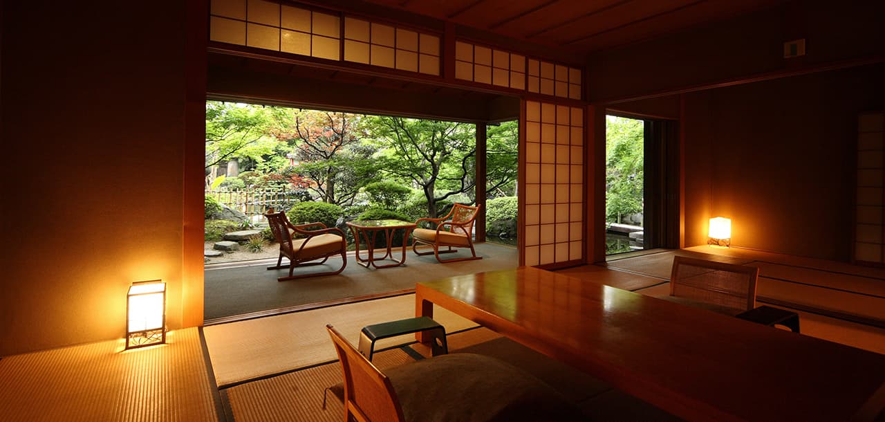 Traditional Japanese guest room at Taisenkaku opening onto a green inner garden with lanterns
