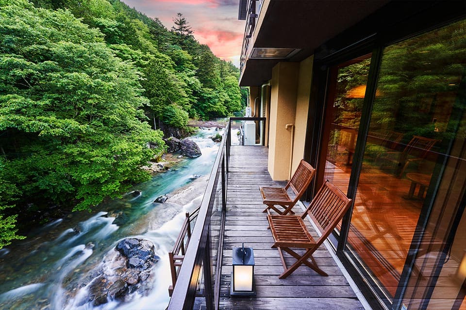 四万温泉 豊島屋 夕景の渓流沿いテラスデッキ © tosimaya.co.jp