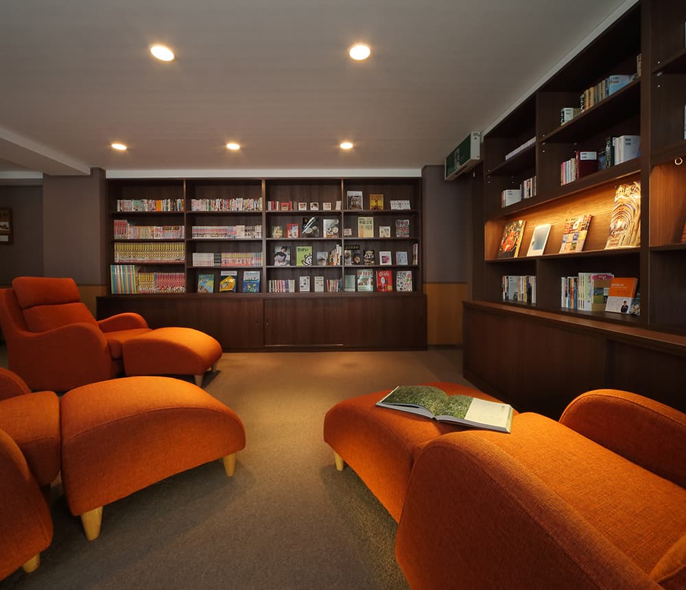 Reading lounge with orange armchairs and bookshelves