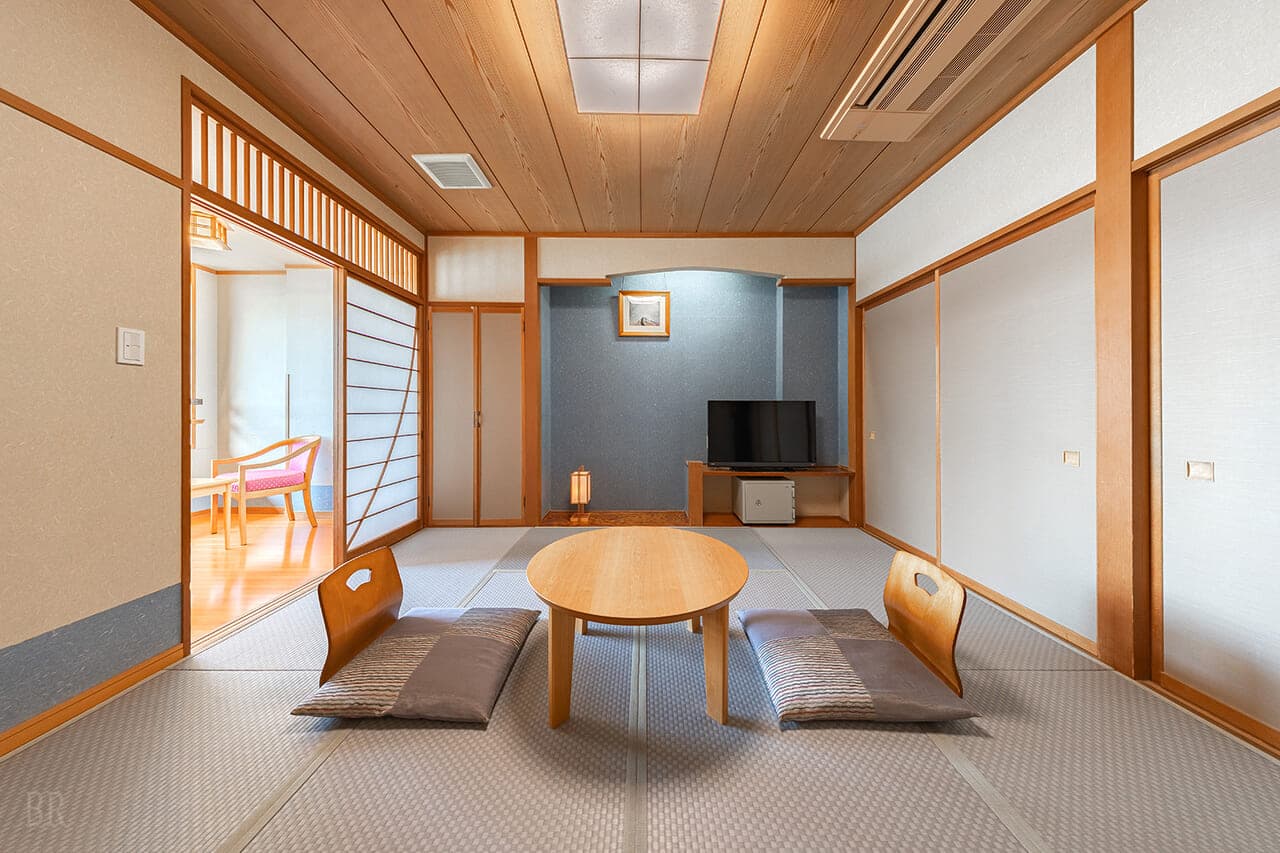 Spacious premium tatami suite at Hotel Asafuji with floor cushions, a low table and an adjoining room