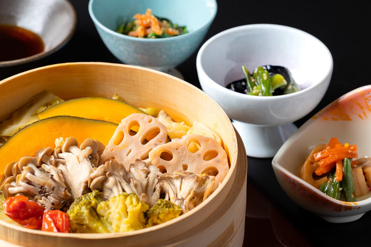 Dinner course at Hotel Asafuji featuring steamed seasonal vegetables in a bamboo basket with small side dishes