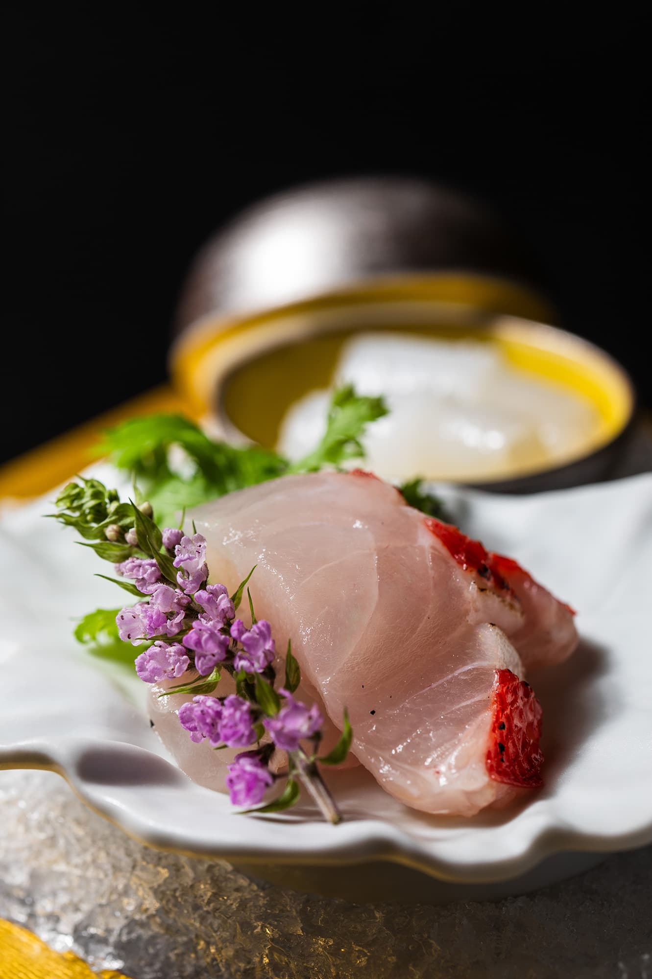 Kaiseki course at Asebino featuring fresh local fish sashimi garnished with edible blossoms on a shell-shaped plate, Izu