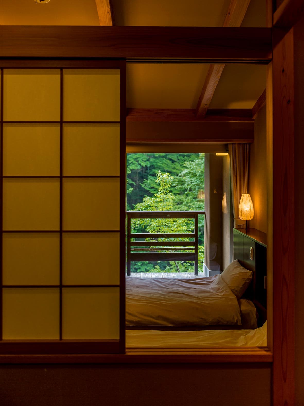 Guest room at Asebino with shoji screens, a made bed and a balcony framing the green valley, Yugashima Onsen Izu