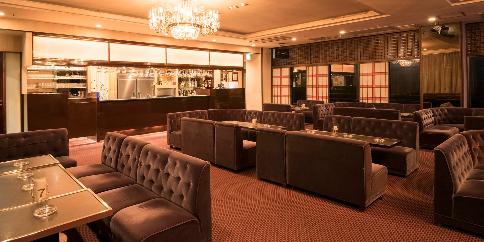 Elegant lounge bar with chandelier, velvet sofas and counter at Atami Taikanso in Atami Onsen