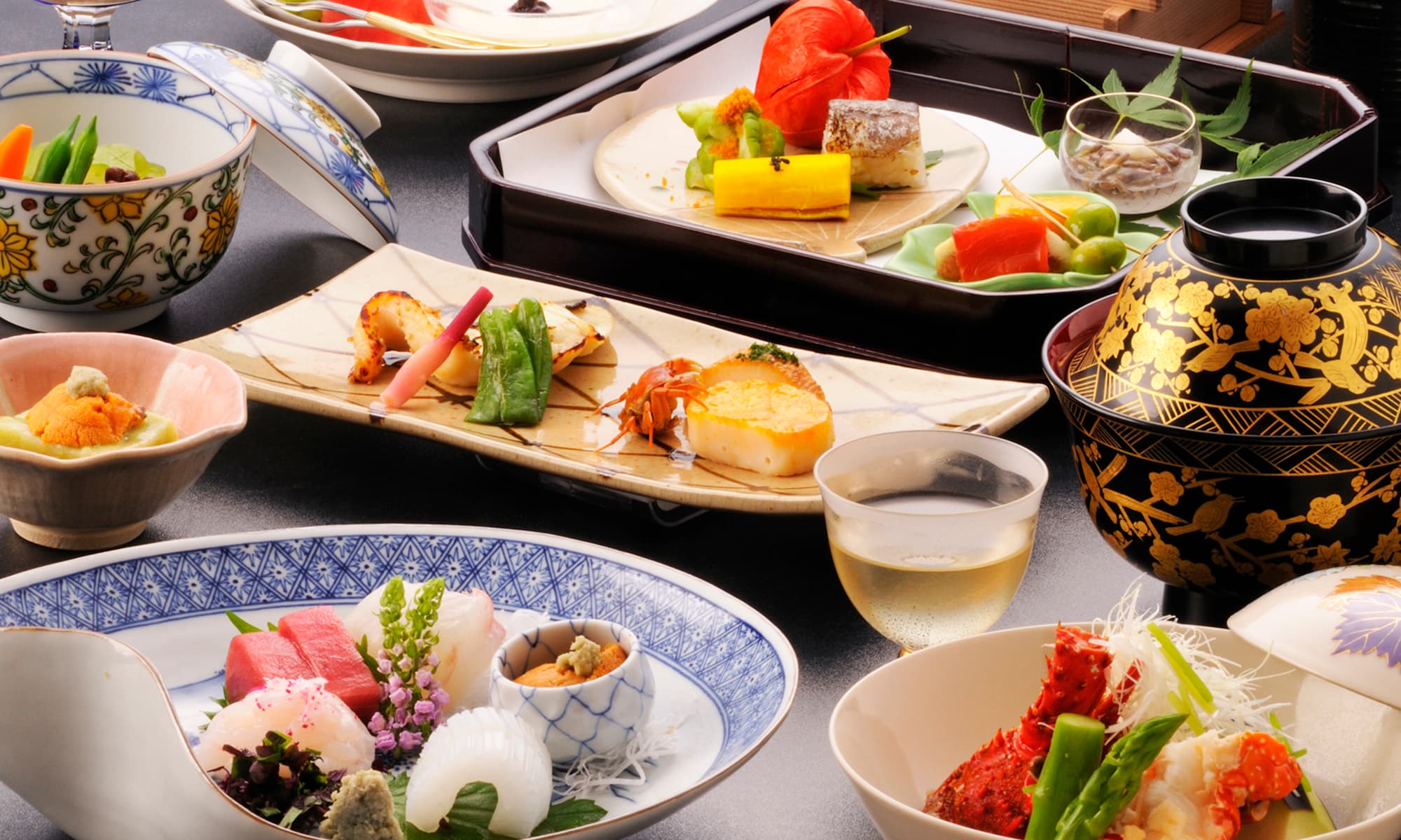 Multi-course kaiseki dinner with sashimi, grilled dishes and lacquerware set on a table at Atami Taikanso
