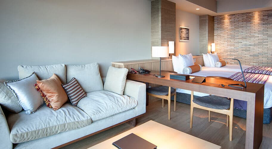 Atami Sekaie Sekaie-wing suite bedroom with sofa, desk and Sagami Bay ocean view