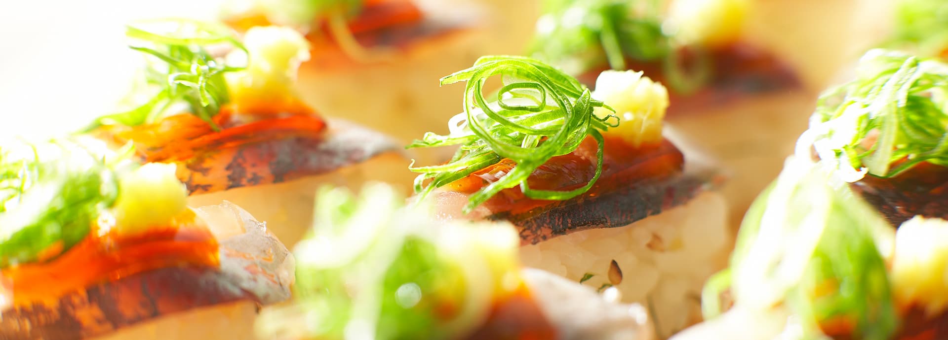 Close-up of a Bousui kaiseki seafood course, seared fish over rice garnished with shredded shiso and yuzu