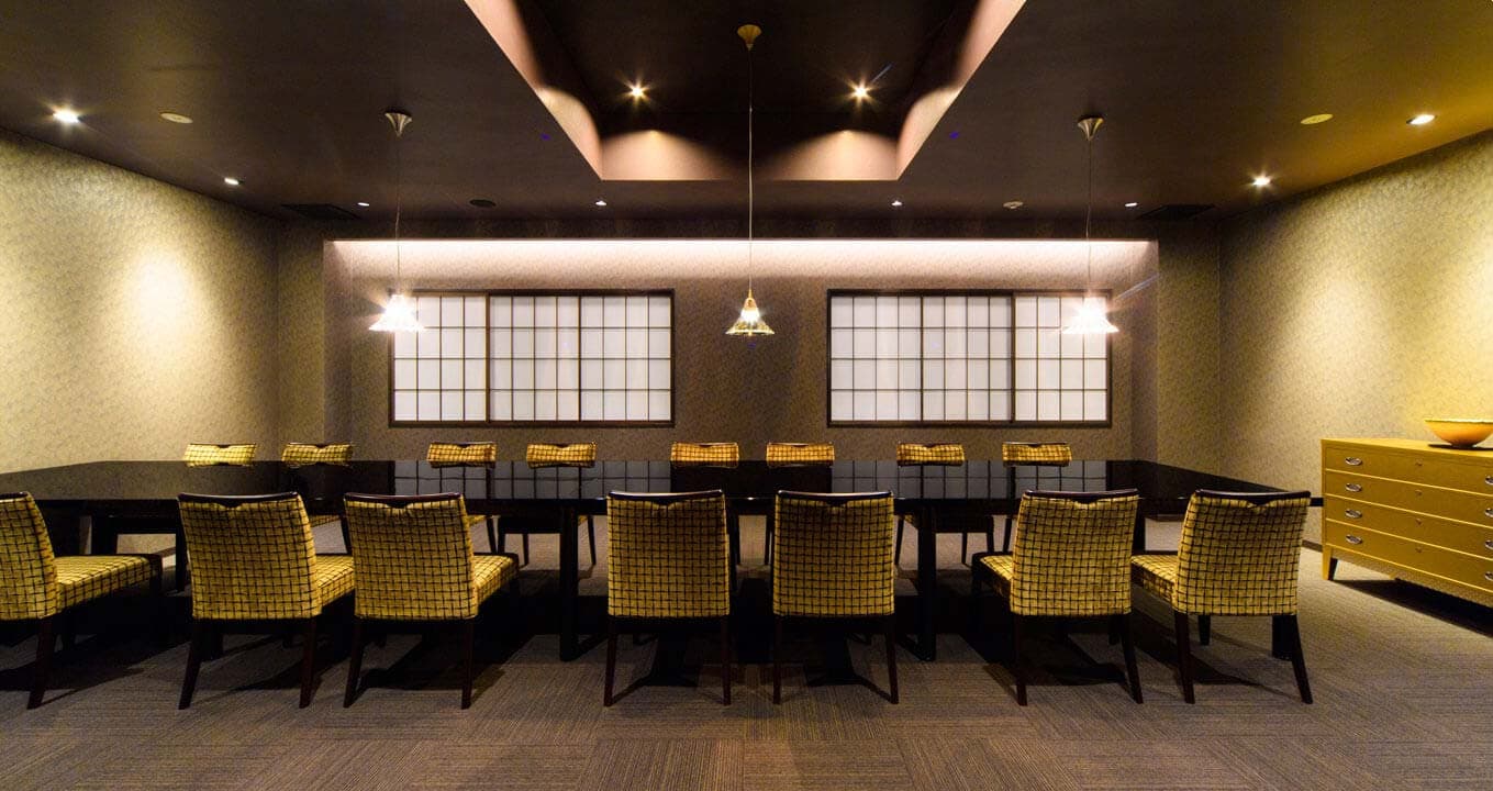Elegant private banquet room with woven-pattern chairs and recessed lighting at Ryokan Kanazawa Chaya in Kanazawa