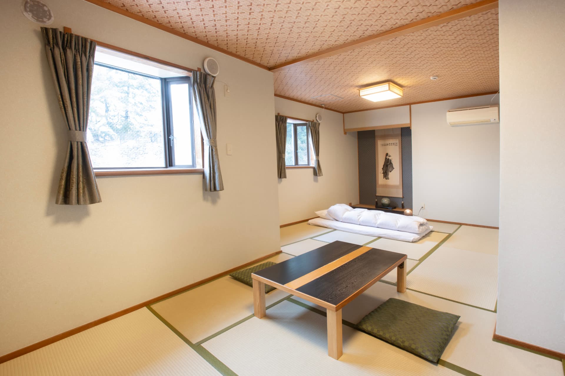 Mountain-side tatami room at Sakuraya with a low table and folded futons