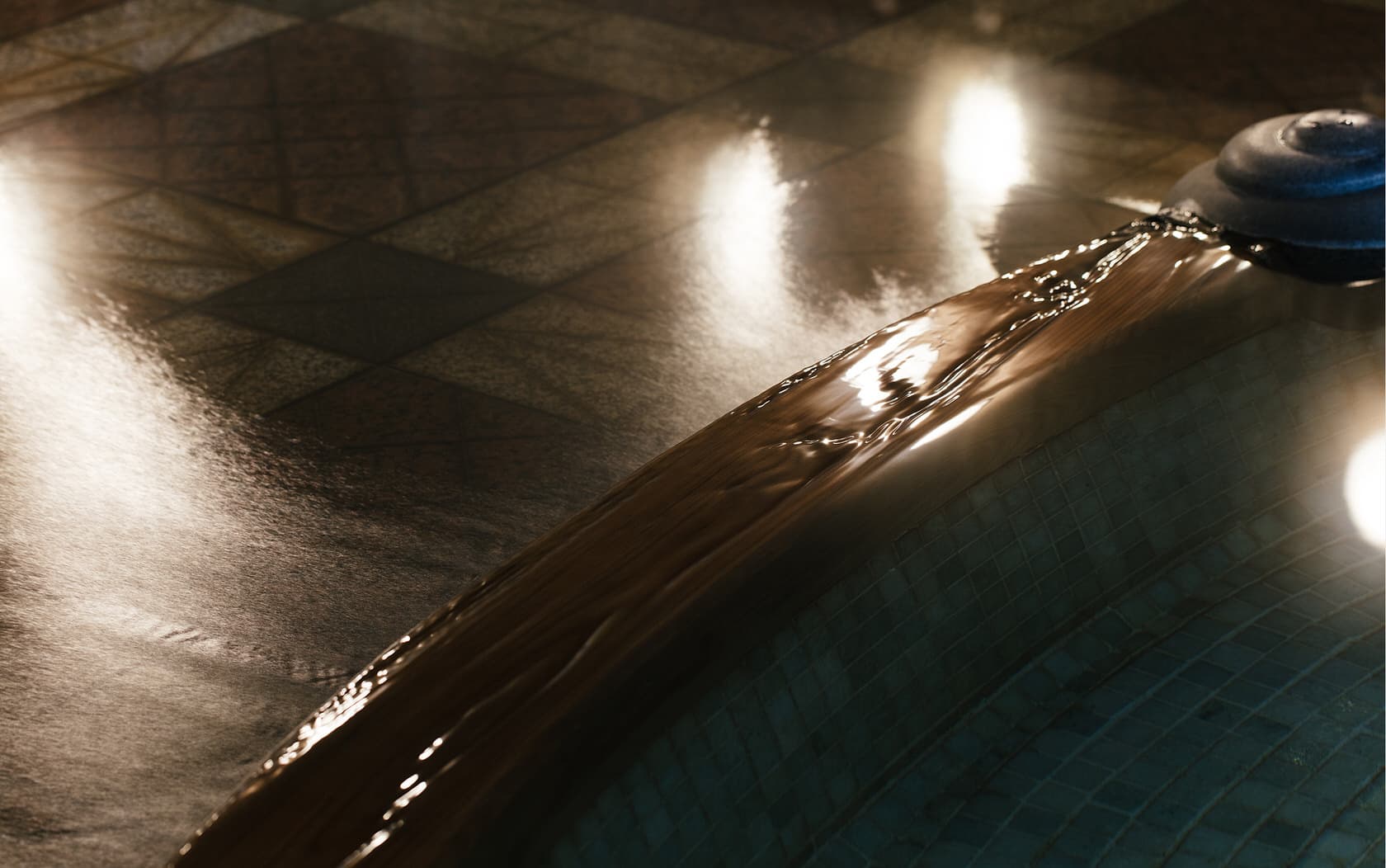 Hot spring water overflowing the tiled rim of the onsen bath at Daimaru Besso under soft lighting