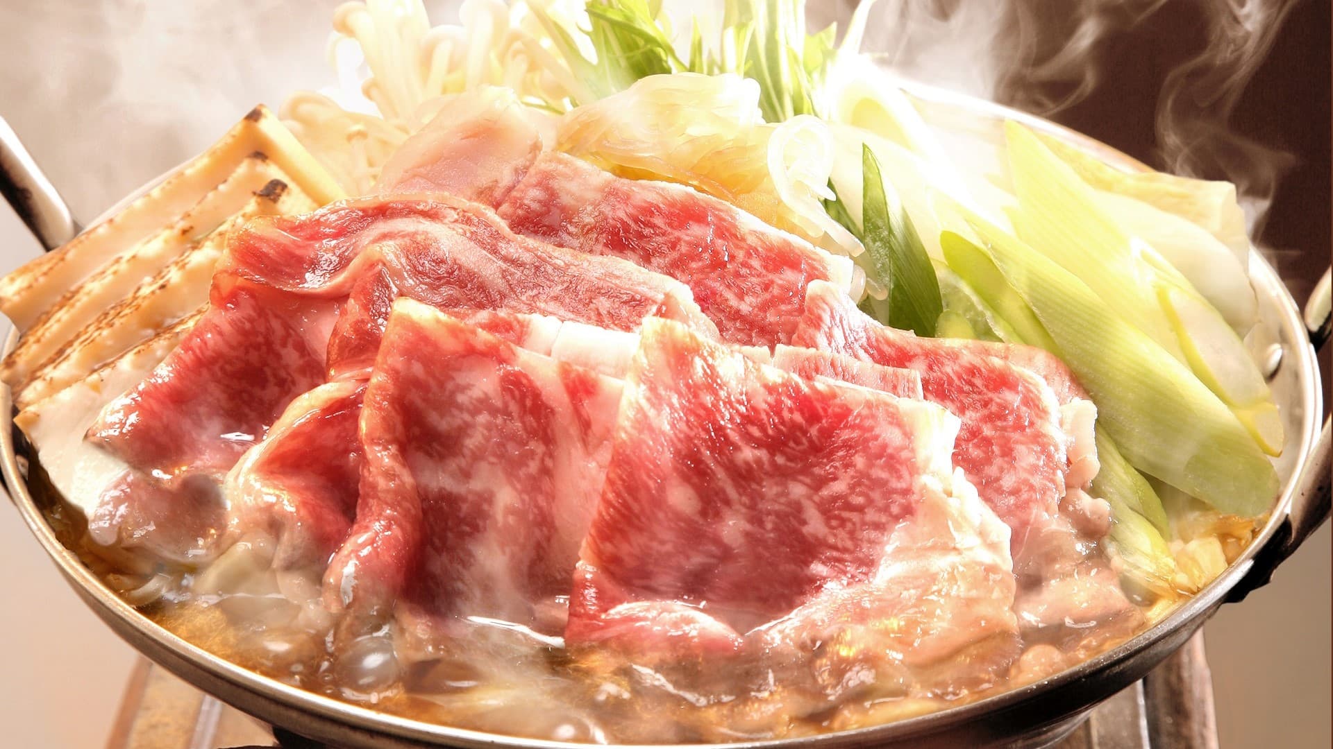 Steaming wagyu beef sukiyaki hotpot with leeks and vegetables served at Ekinariya Ryokan