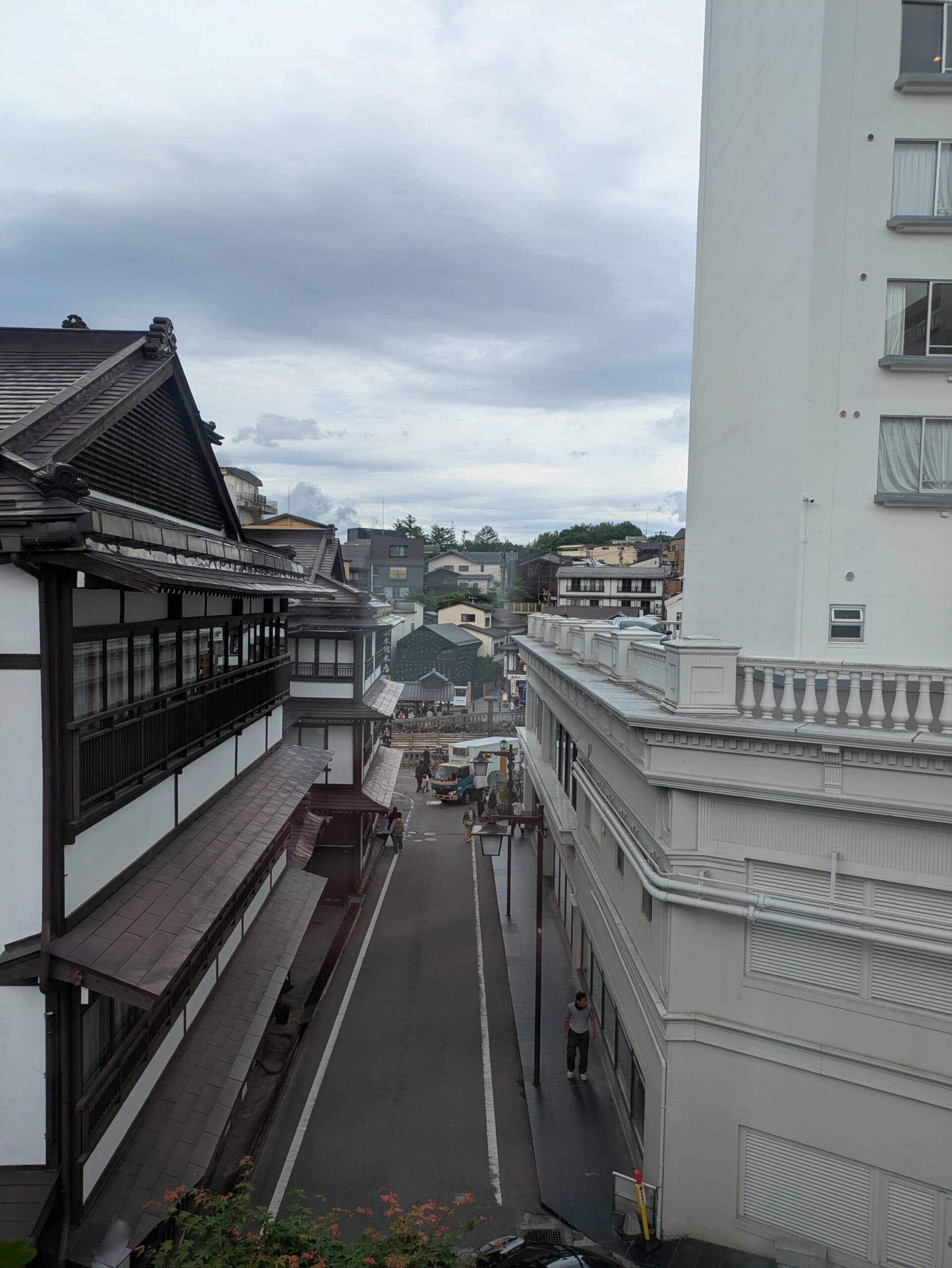 View over the historic Kusatsu Onsen townscape and wooden ryokan rooftops from Ekinariya Ryokan