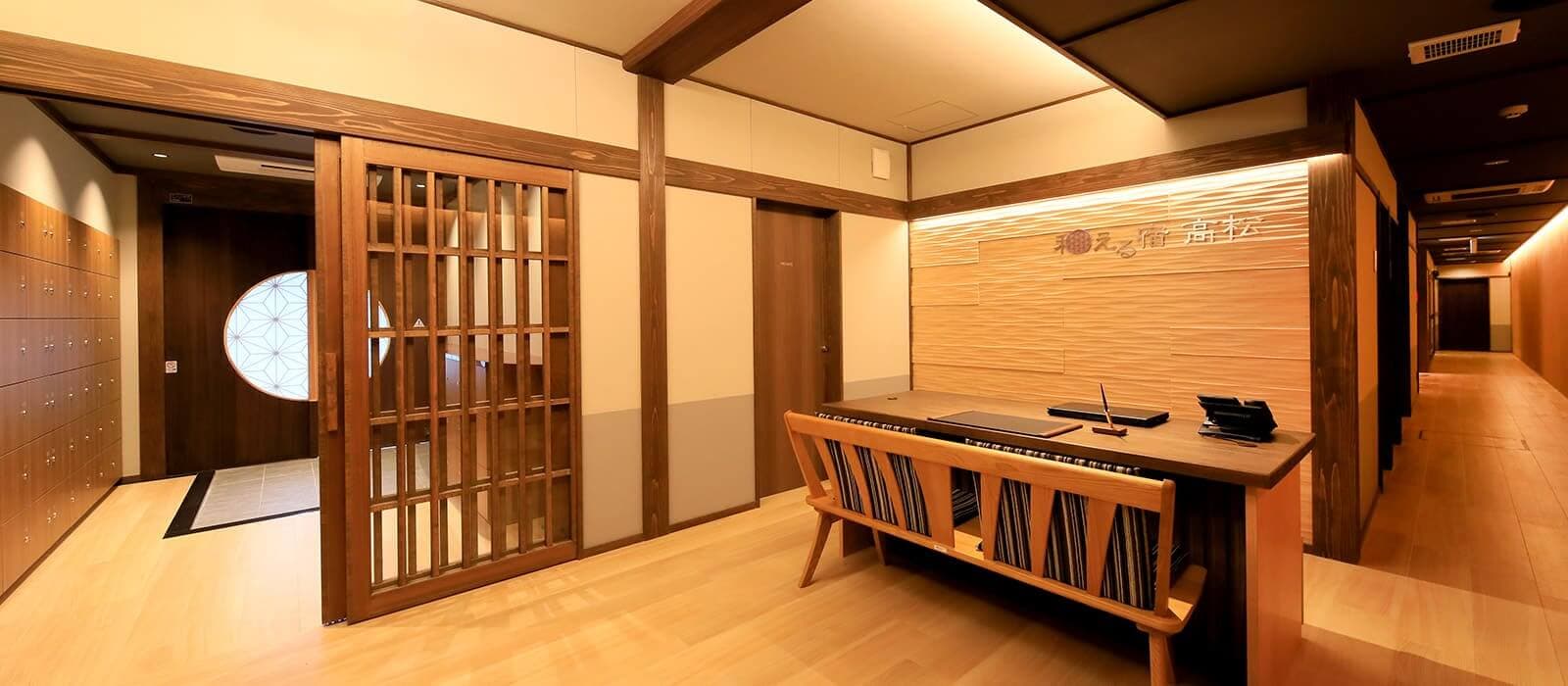 Wood-paneled reception and lobby with shoji screen, lockers and long corridor
