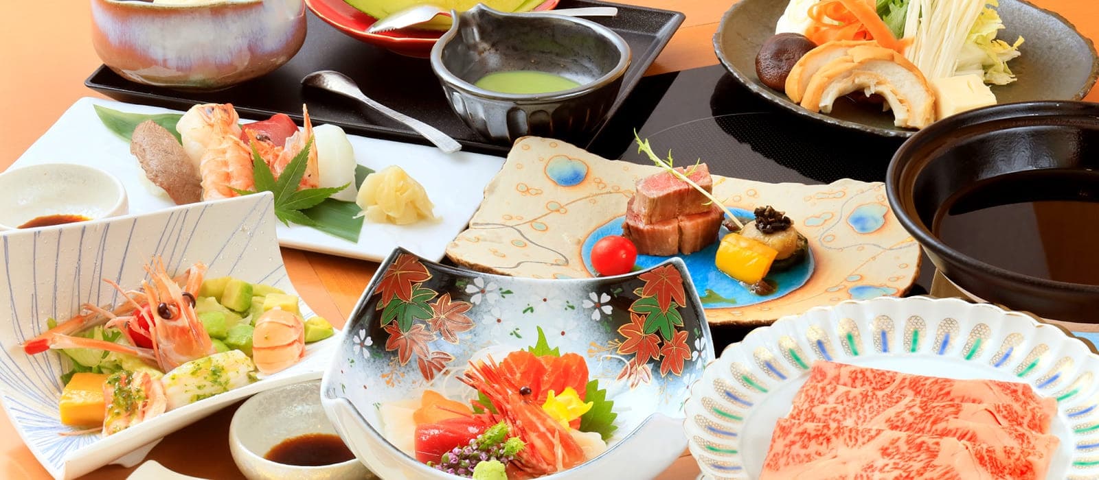 Multi-course kaiseki dinner spread with sashimi, marbled wagyu beef and seasonal dishes