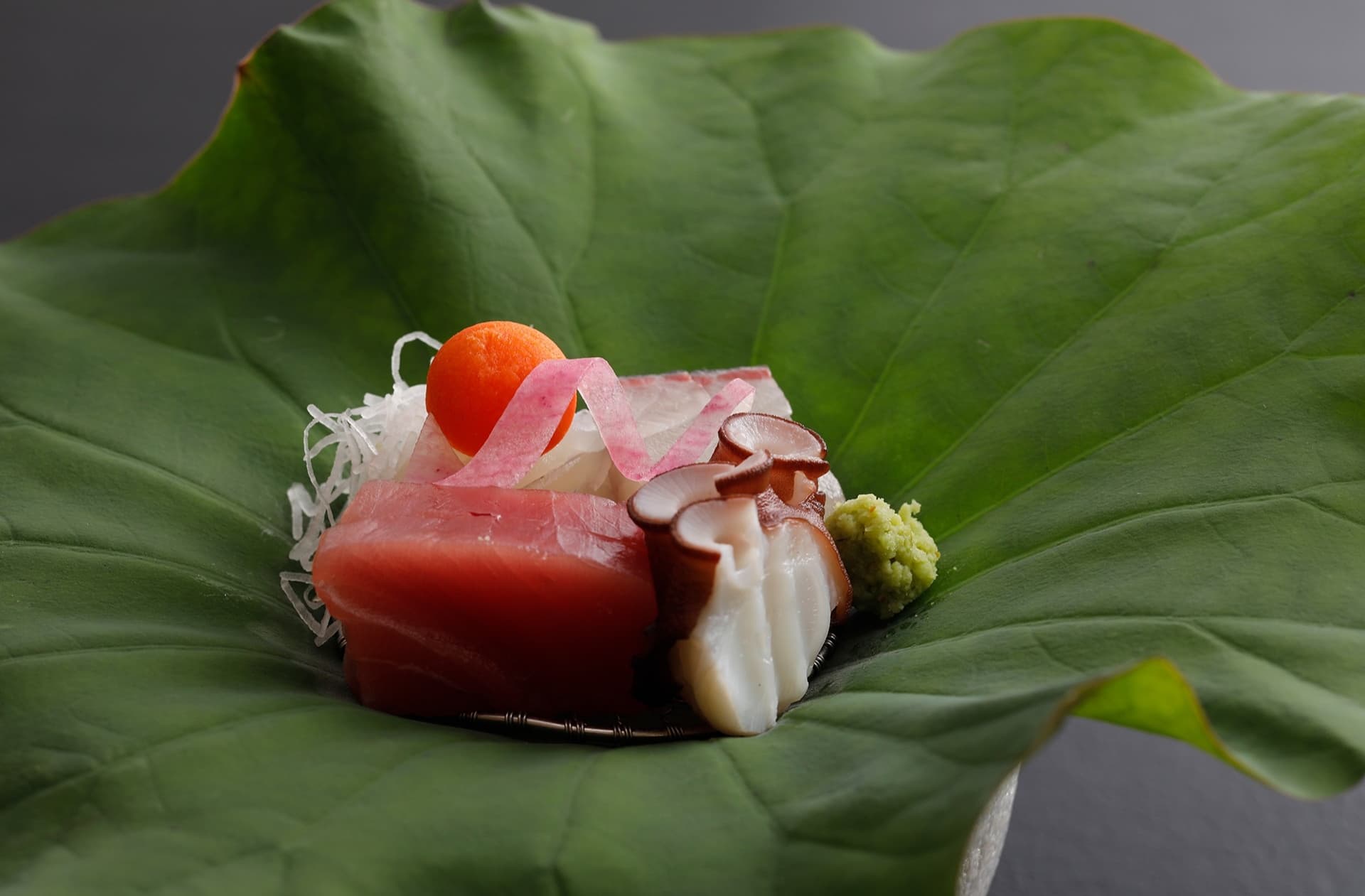 Sashimi of tuna and white fish presented on a fresh green lotus leaf at Miyukiso Hanamusubi