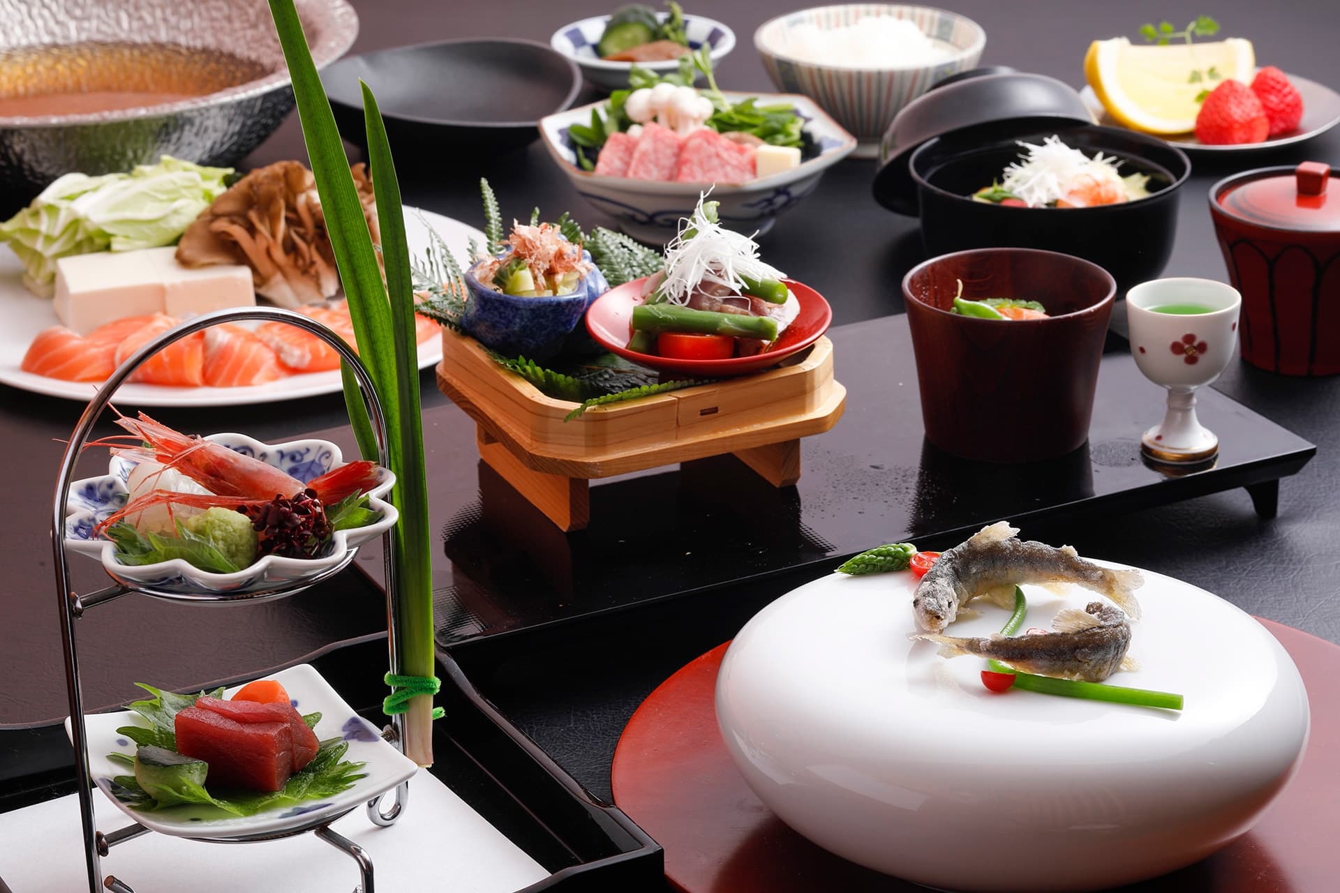 Seasonal kaiseki dinner spread at Miyukiso Hanamusubi with sashimi, simmered dishes and Tamba beef arranged on a black lacquer table