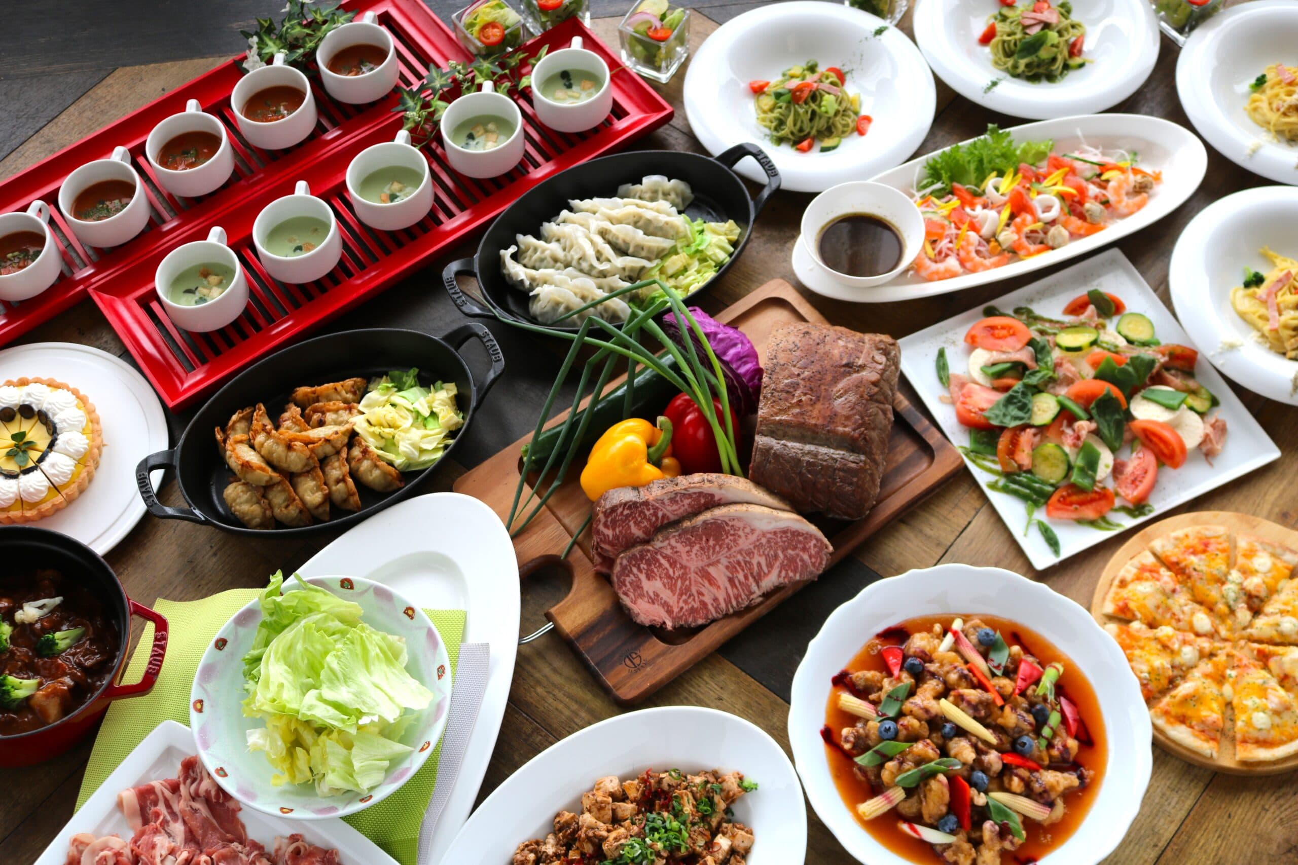 Dinner buffet spread at Hotel Village with roast beef, soups, salads and pizza laid across a wooden table