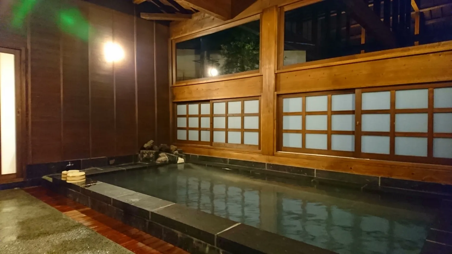 Indoor uchiyu bath in warm wood and stone at Ryokan Ichinoi