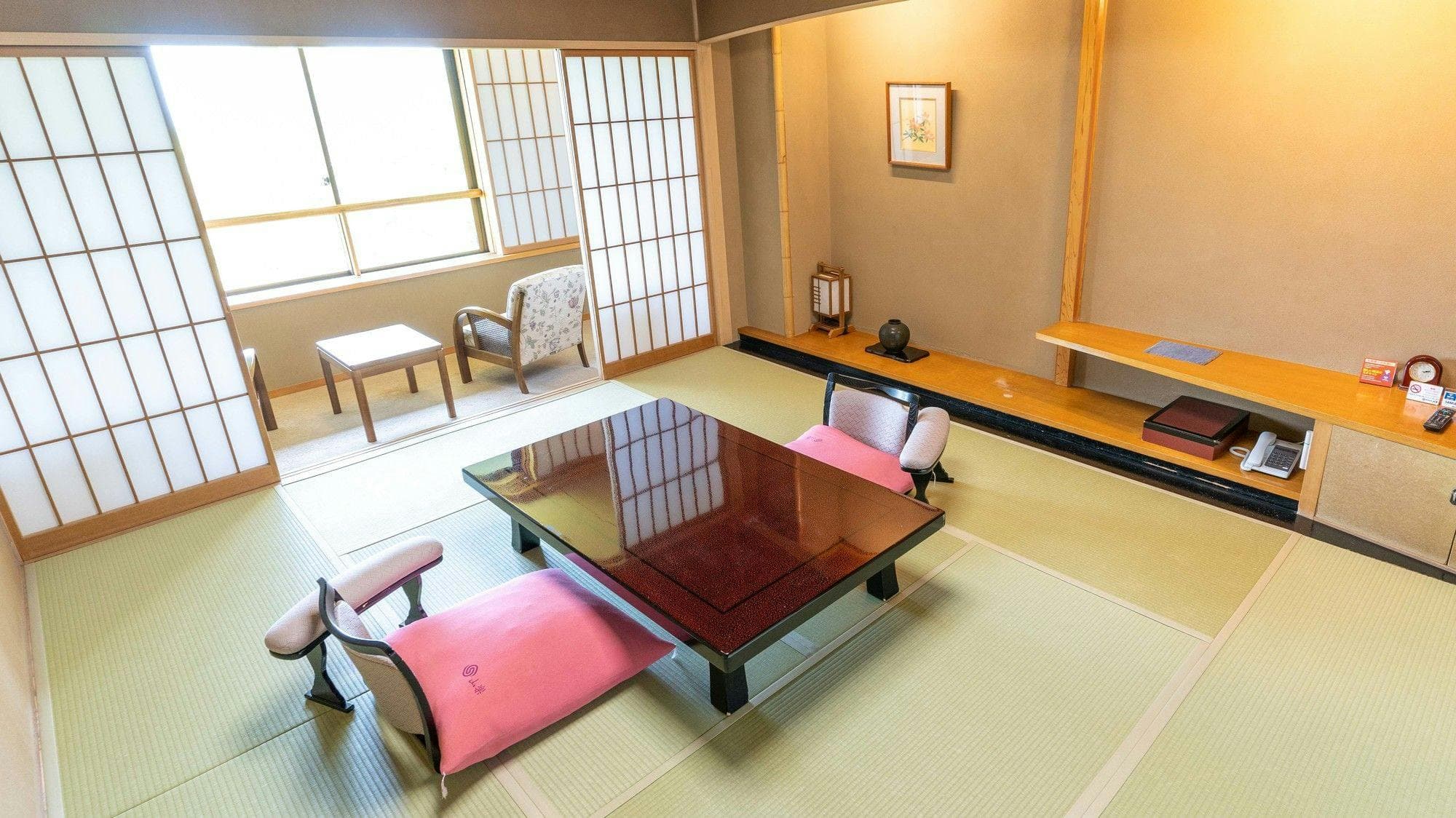 Spacious Japanese room with low table and pink floor cushions
