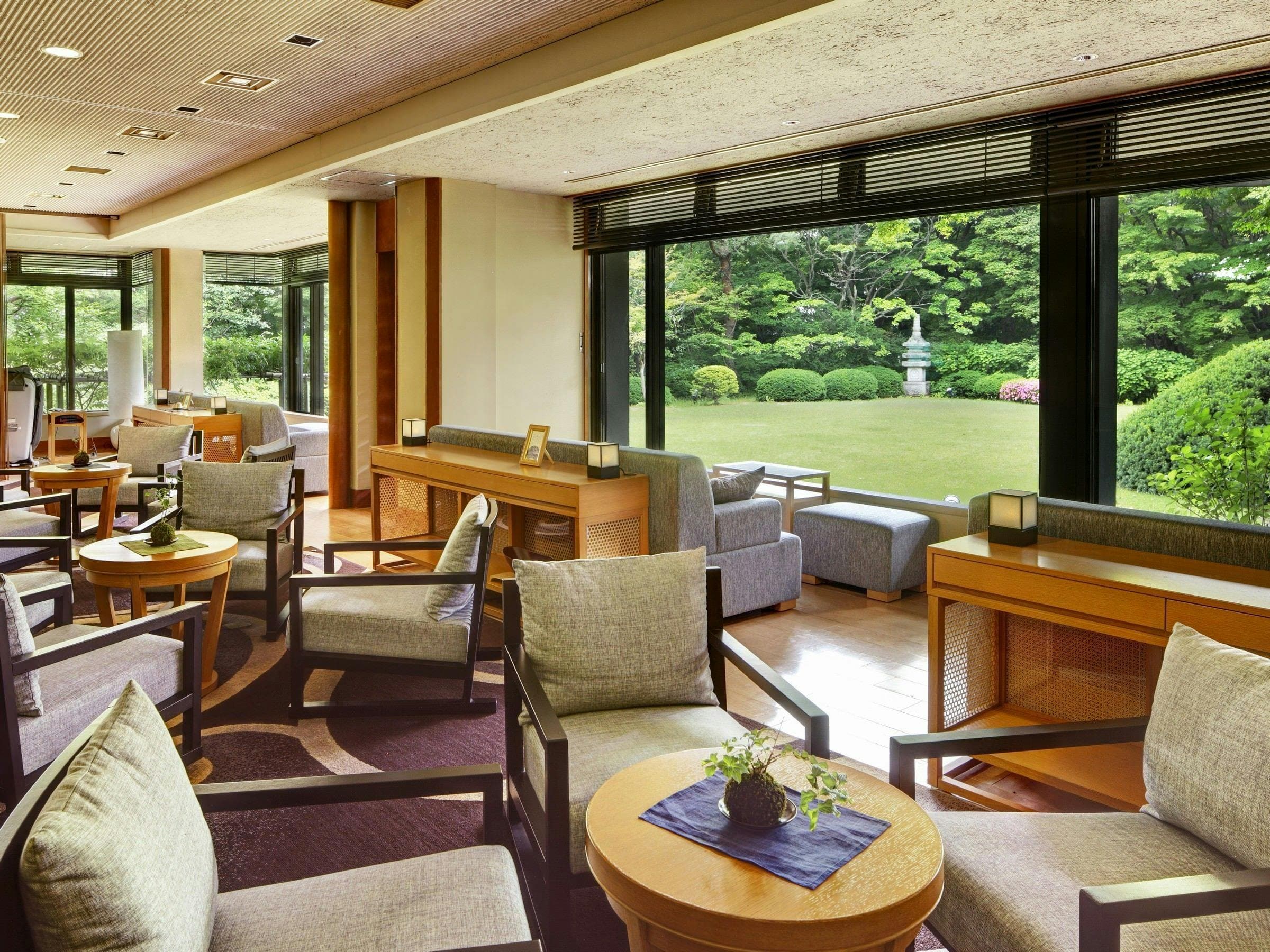 Lounge with armchairs and floor-to-ceiling windows onto the garden