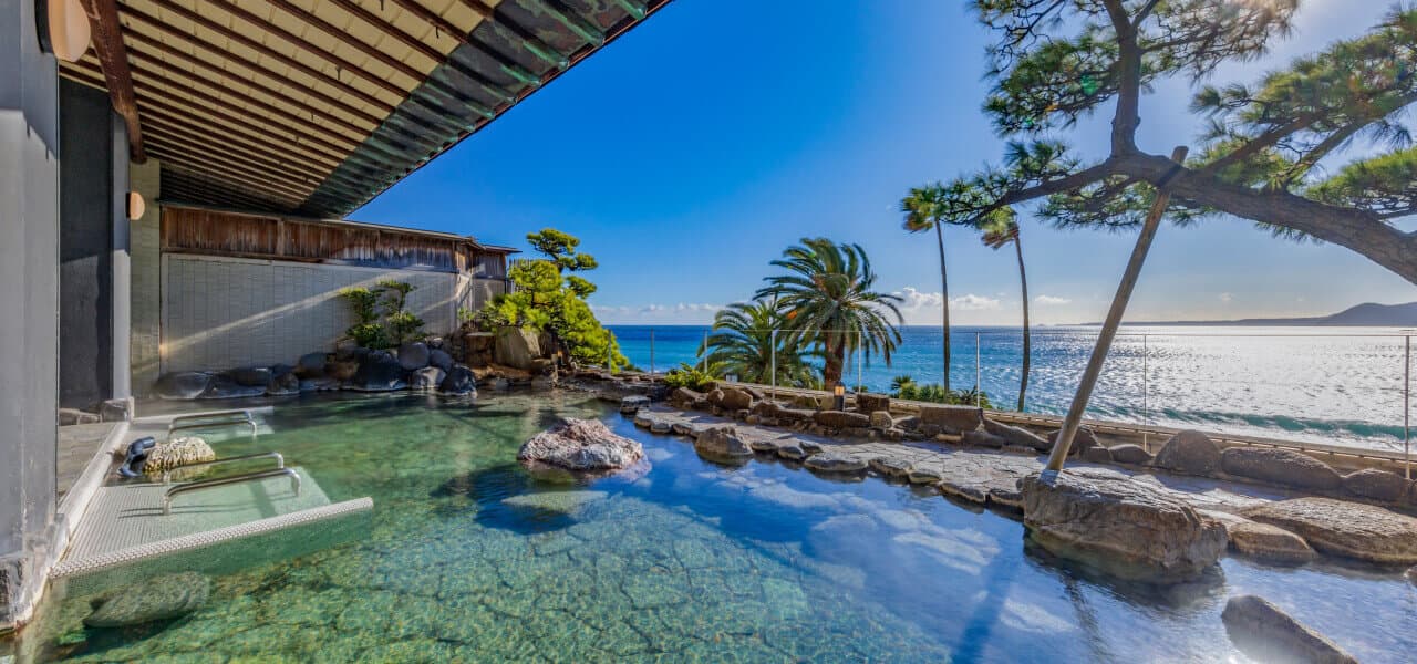 Open-air rotenburo hot spring bath overlooking the blue Pacific Ocean at Inatori Ginsuiso, Izu