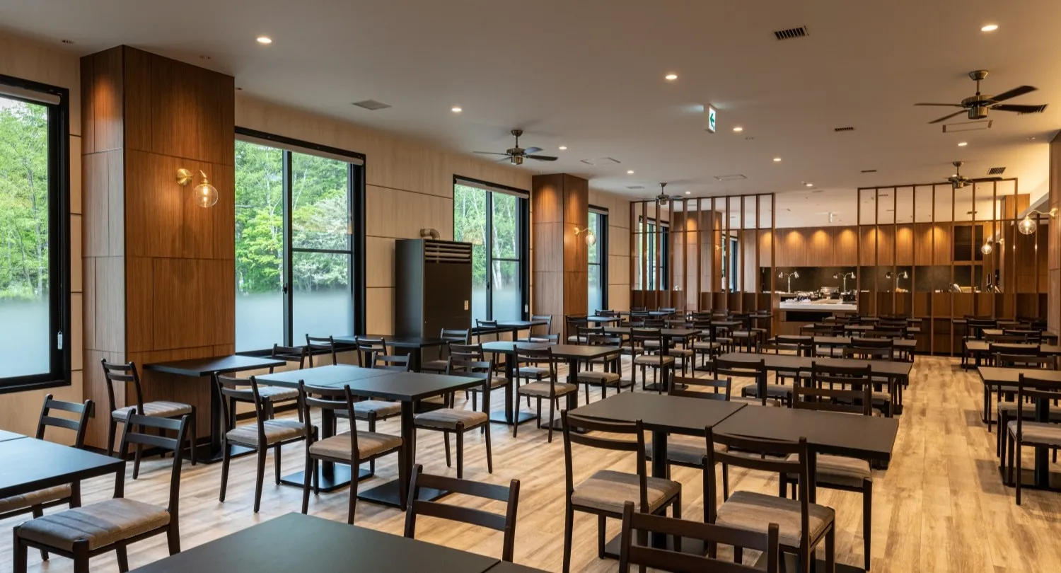 Light-filled buffet dining hall with wooden interior, ceiling fans and forest views at Kamenoi Hotel Okunikko-Yumoto