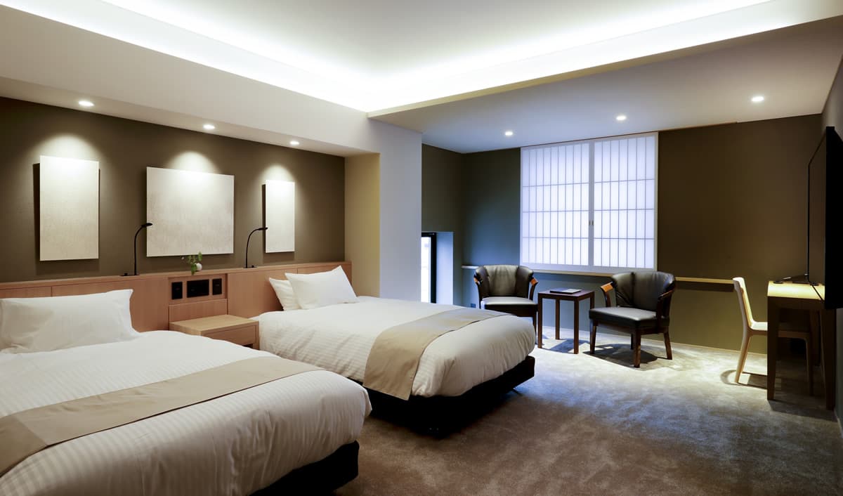 Twin-bed Western-style guest room with carpet, armchairs and shoji-screened windows at Kaminarimon Ryokan in Asakusa