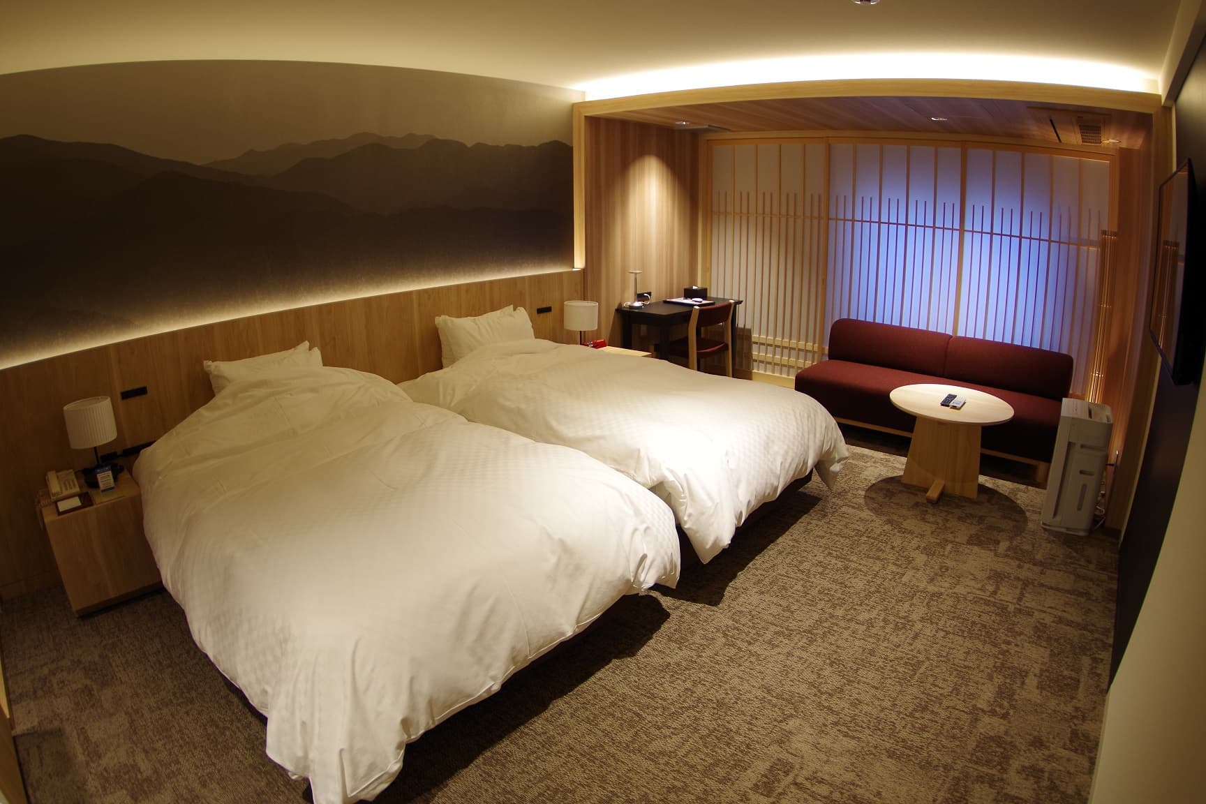 Japanese-modern twin guest room with a mountain mural, shoji screens and warm lighting at Kasuga Hotel