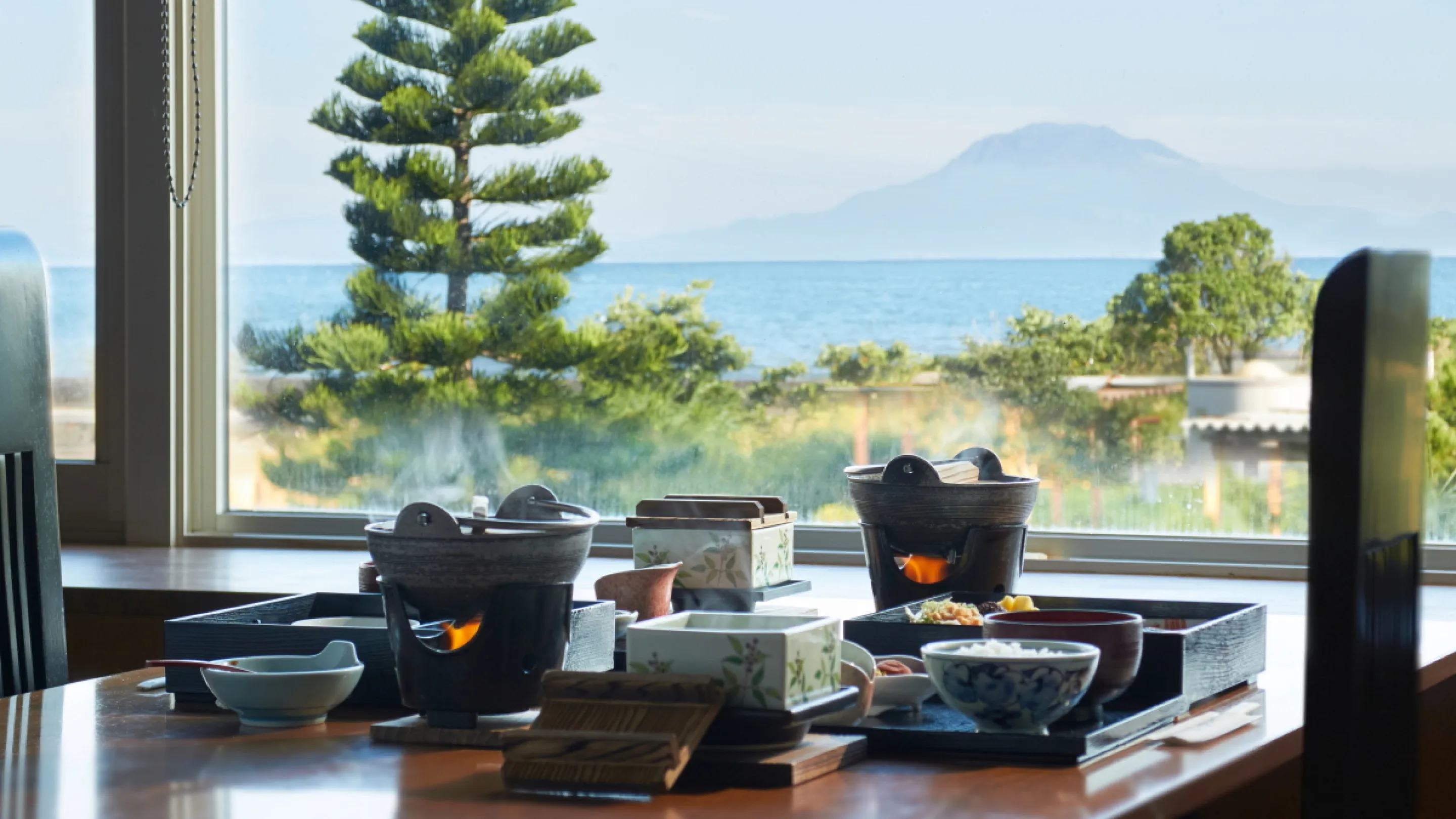 Japanese breakfast set on a table with an ocean and Sakurajima view at Koran no Yu Kinkouroh in Ibusuki