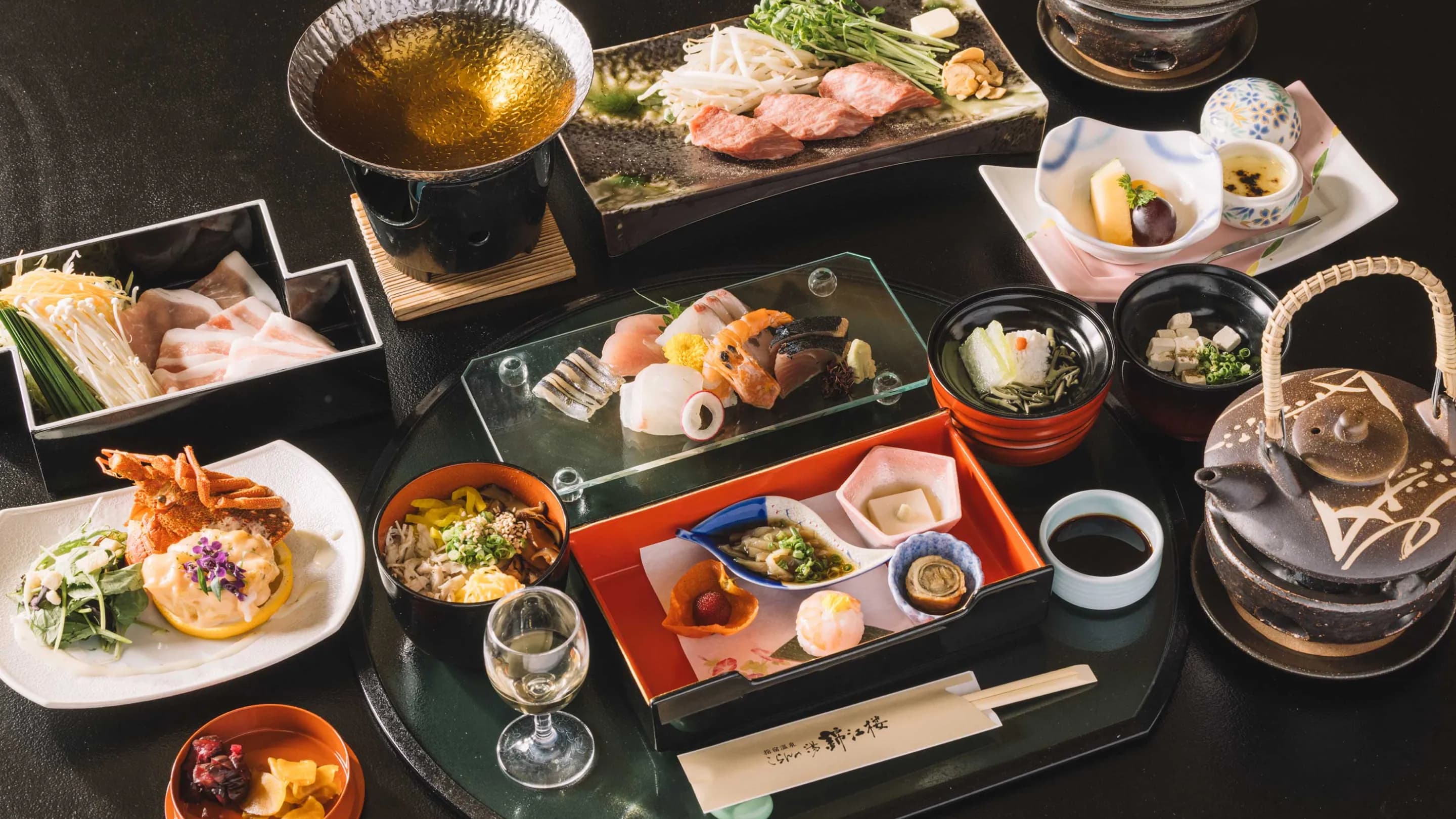 Multi-course kaiseki dinner spread with wagyu, sashimi and small dishes at Koran no Yu Kinkouroh in Ibusuki
