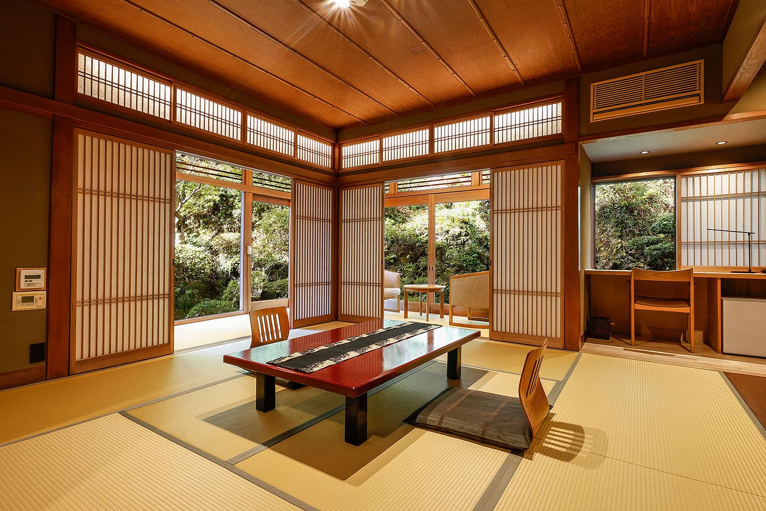 Spacious tatami guest room with low lacquer table and shoji screens opening to a garden, Yamamotoya, Kinosaki Onsen