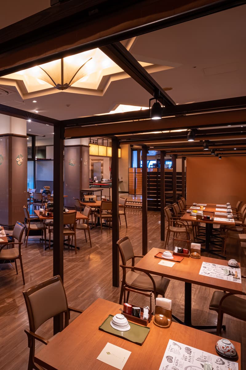 Restaurant interior at Kinsuikan with warm wood tables and a decorative star-shaped ceiling light